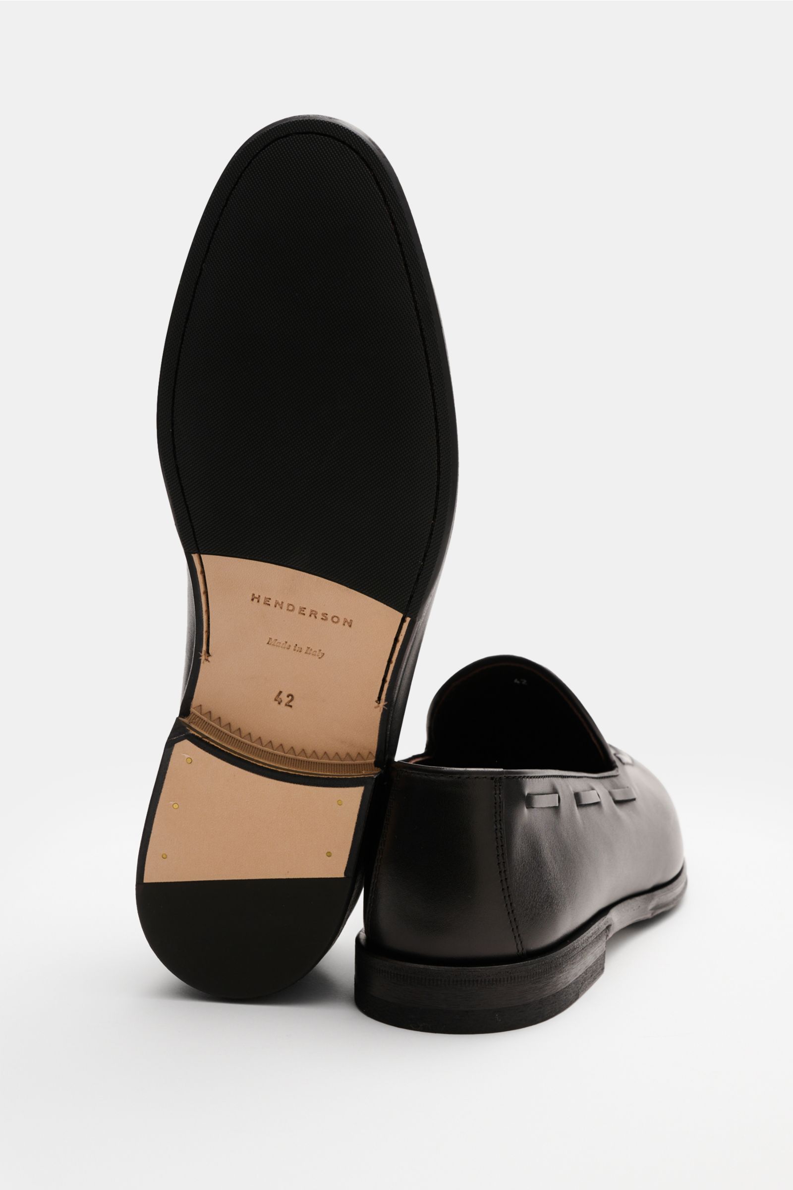 Henderson Tassel Loafer dunkelbraun shown from side and sole view, handcrafted dark brown calf leather shoe with leather and rubber sole.

Ein Statement klassischer Eleganz: Der edle Tassel Loafer von HENDERSON aus handantiquiertem Kalbsleder mit umlau