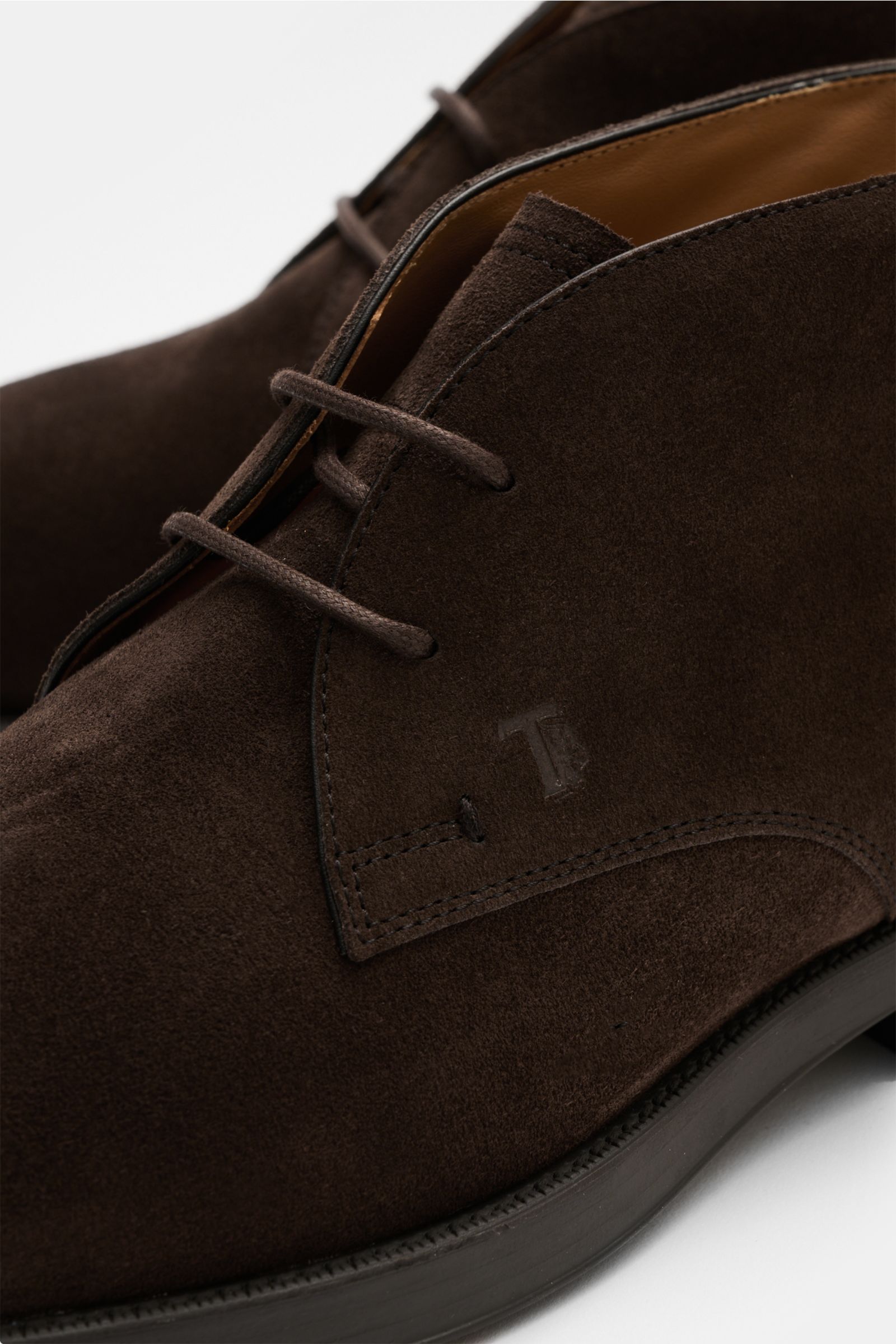 Close-up seitliche Ansicht des dunkelbraunen Tod's Desert Boot 'Polacco' aus edlem Veloursleder mit offener Zwei-Loch-Schnürung und genoppter Gummisohle.