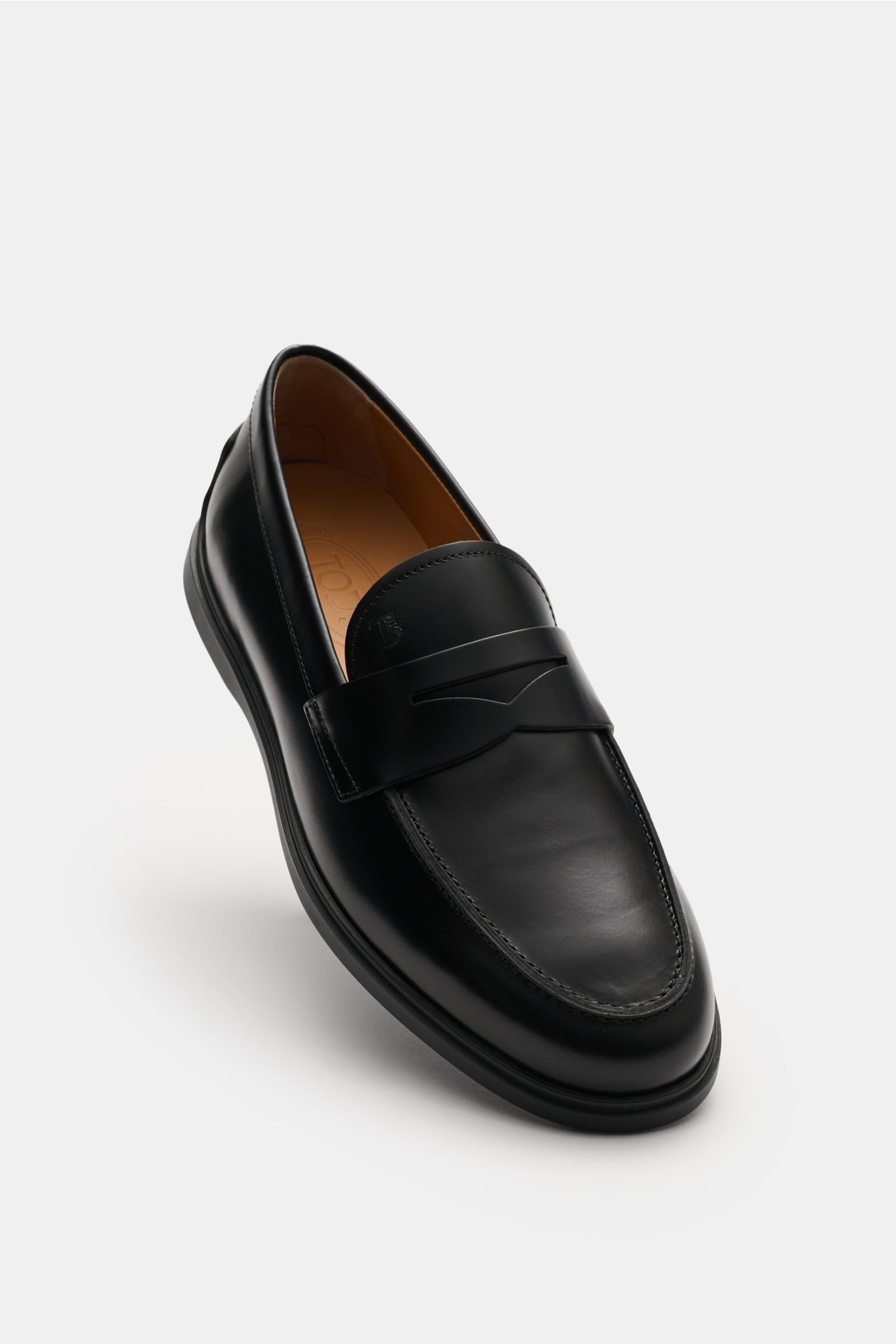 Tod's Penny Loafer schwarz aus edlem Glattleder, leicht schmal zulaufend, mit typischem Penny Strap, Steppnaht vorne, Noppendetail an Ferse, Gummi-Laufsohle mit Noppen, made in Italy, seitliche Draufsicht.