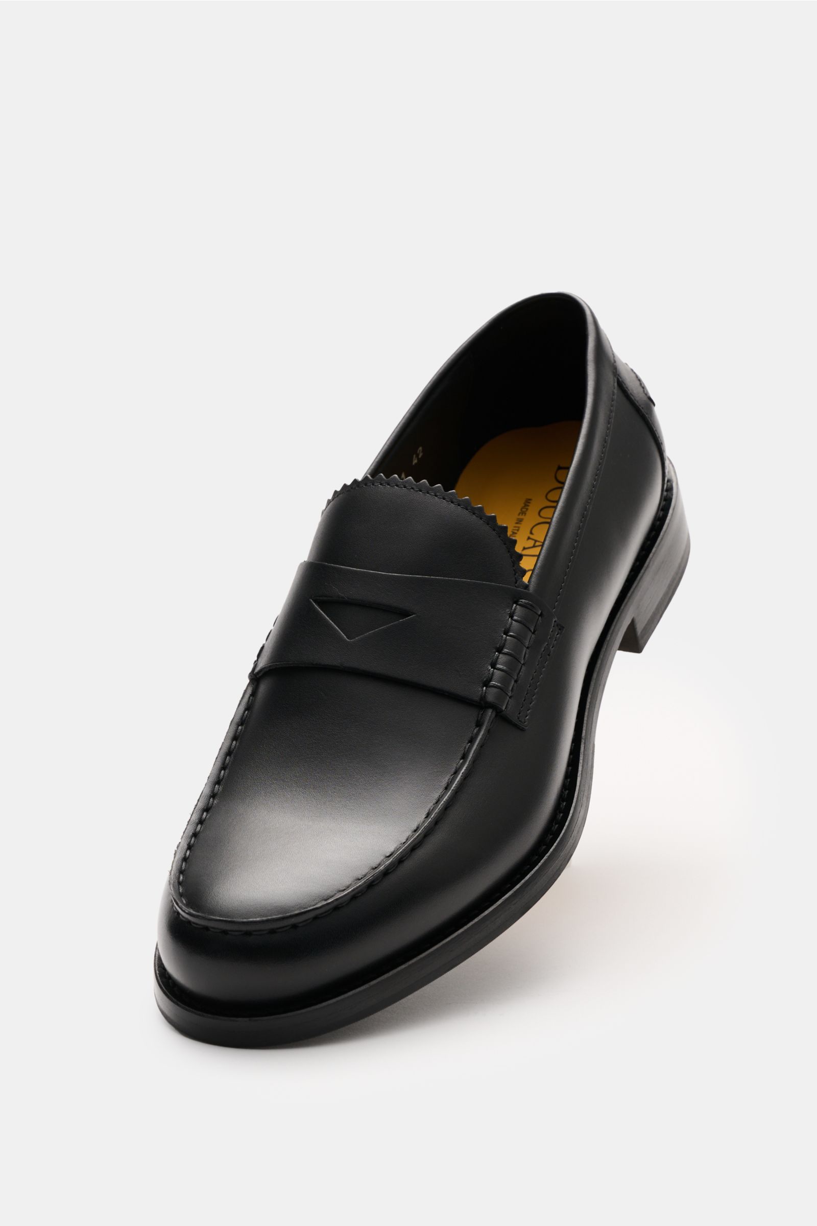 Doucal's Penny Loafer 'Deco' schwarz shown from a front-side angle, made of feines Glattleder, leicht schmal zulaufend with typischer Penny Strap, Vorderkappe mit Steppnaht, ledernes Innenfutter, and robuste Sohle aus Kautschuk.
