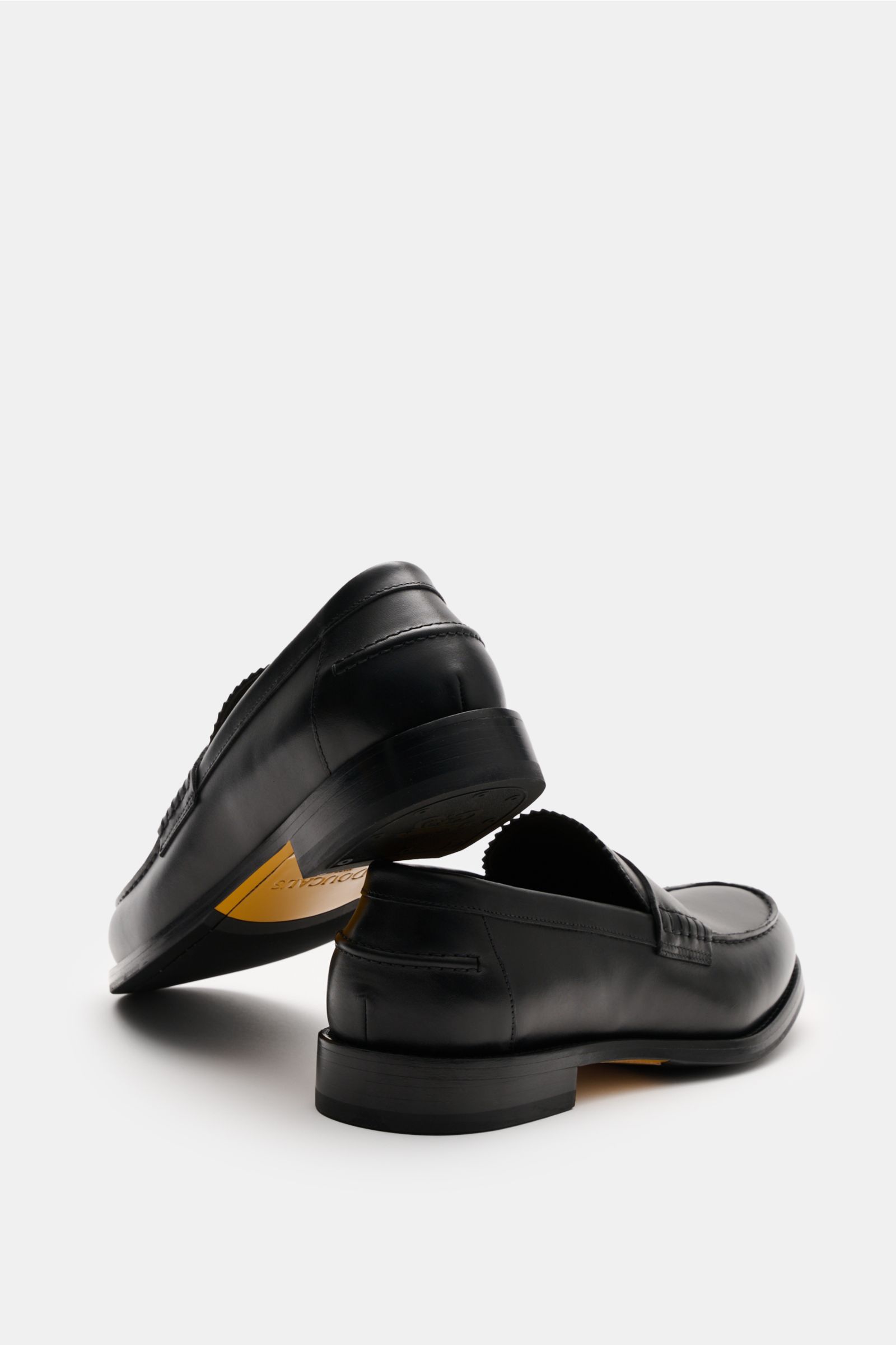Doucal's Penny Loafer 'Deco' schwarz shown from rear side and slightly above, made of feines Glattleder, leicht schmal zulaufend, typical Penny Strap, Vorderkappe mit Steppnaht, ledernes Innenfutter, and robuste Sohle aus Kautschuk.