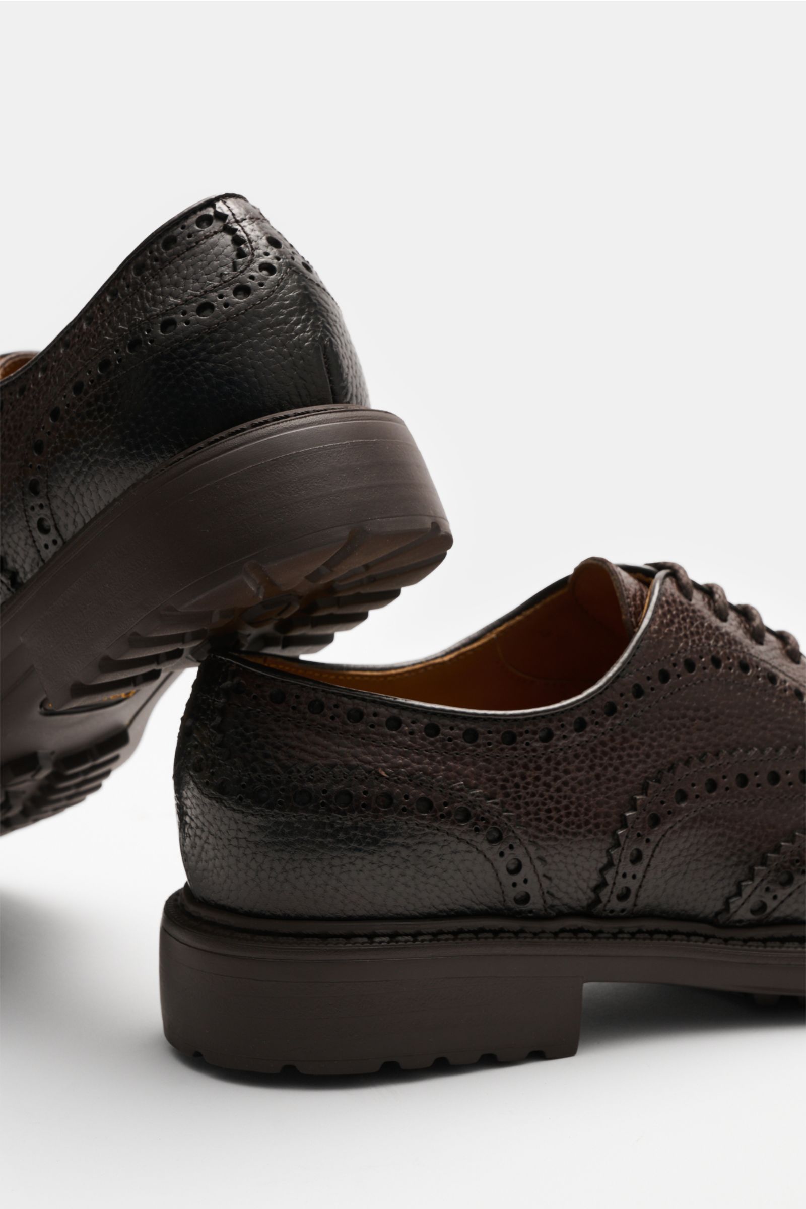Doucal's Oxford dunkelbraun seitlich und von unten fotografiert, genarbtes Leder, aufwändige Brogueings, schmale Silhouette, Blake-Verarbeitung.