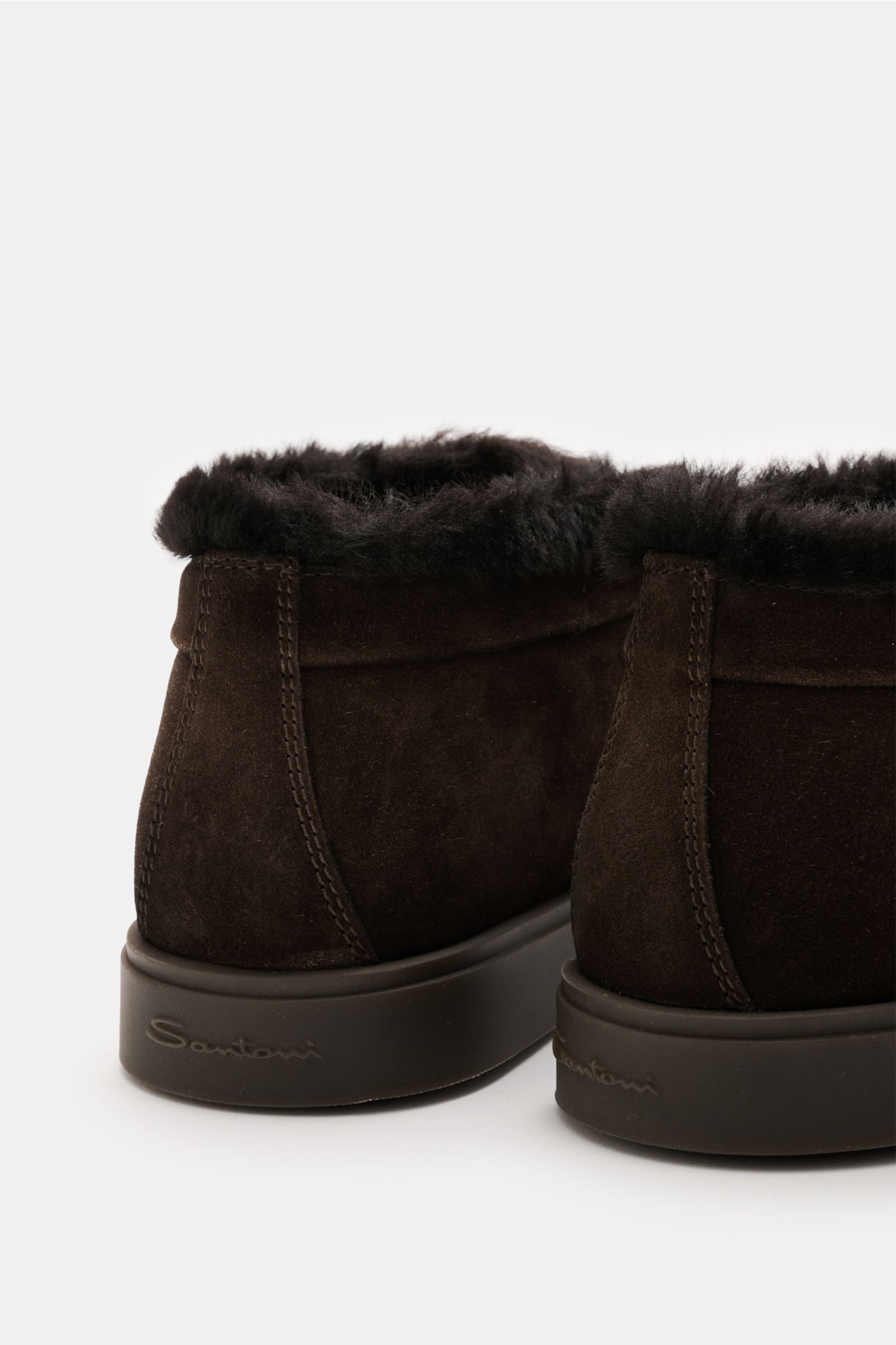 Rear close-up of Santoni Desert Boot 'Detroit Rock' dunkelbraun, showing soft dark brown velour suede, plush fur lining, slim silhouette, decorative toe stitching, leather interior, and rugged rubber sole.

Description: Desert Boot aus feinem Textur-Wi