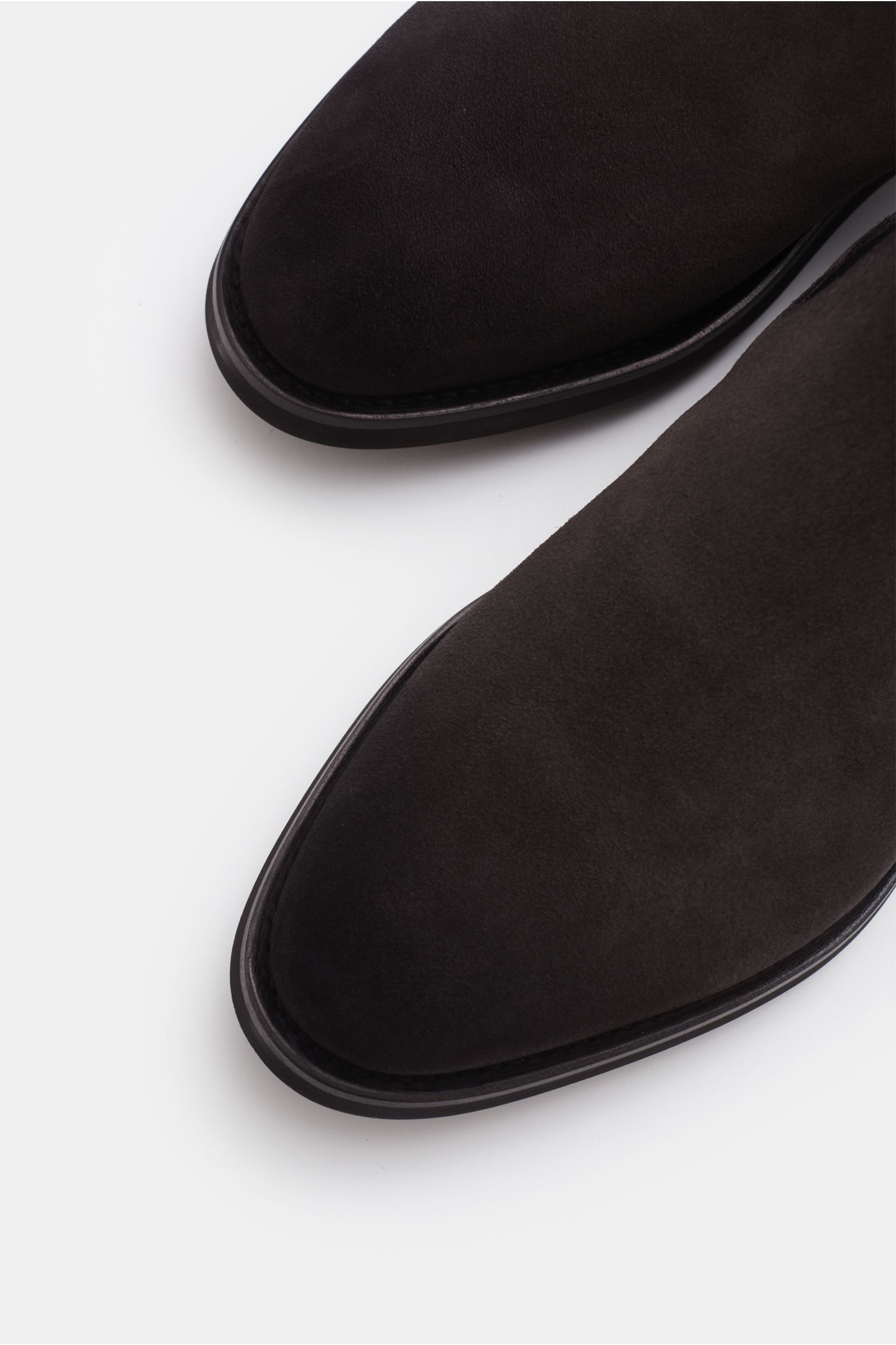 Santoni Chelsea Boot 'Colin' graubraun aus Veloursleder, schmal zulaufend, rahmengenäht, mit seitlichen Elastikeinsätzen, Anziehschlaufe, ledernem Innenfutter, Kautschuksohle, Nahaufnahme von oben auf die Schuhspitzen.