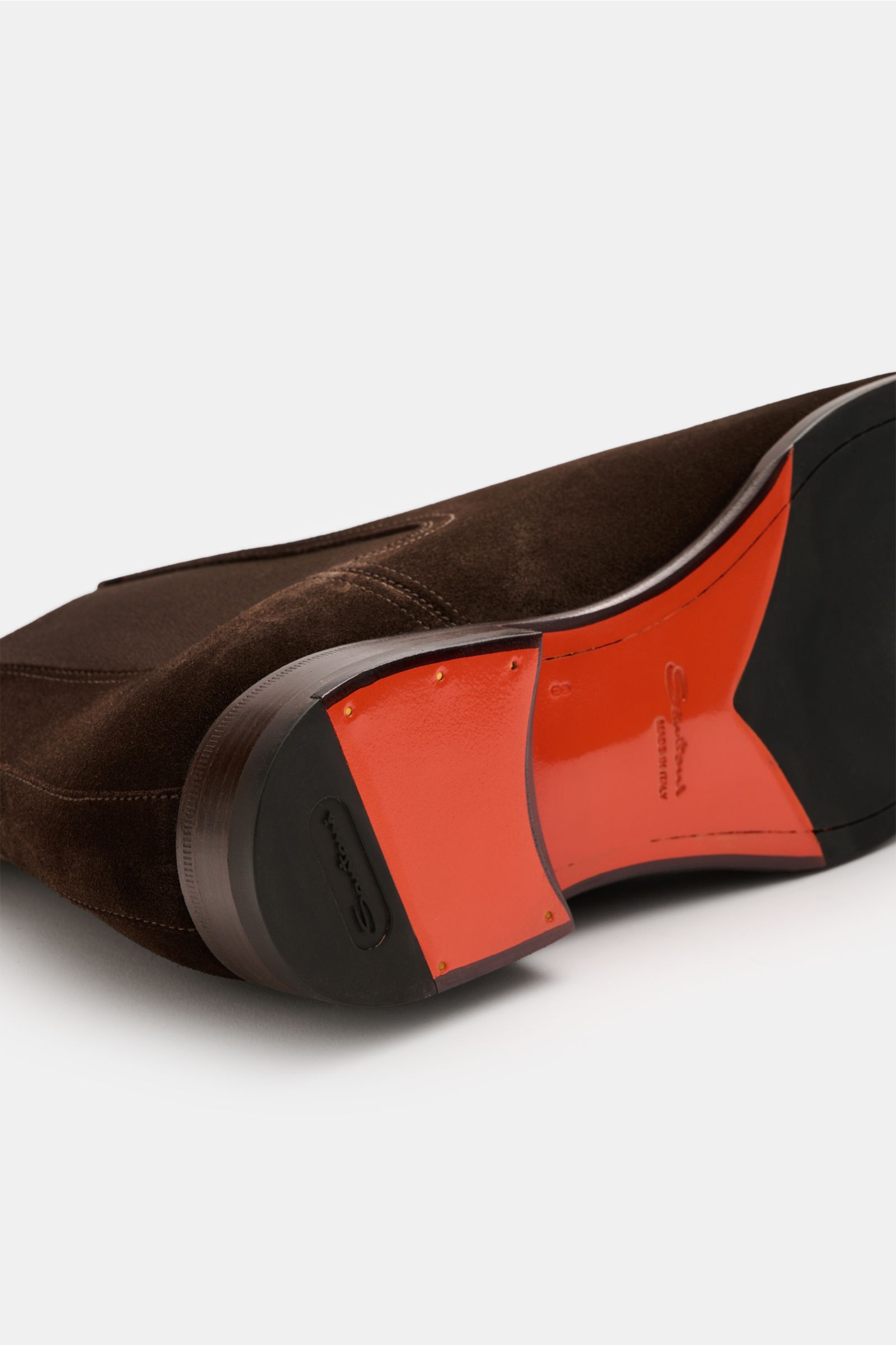 Santoni Chelsea Boot 'Adrian' braun aus geschmeidigem Veloursleder, schmal zulaufend, mit roter Leder-Kautschuk-Laufsohle, seitlich elastisch, von unten fotografiert.
