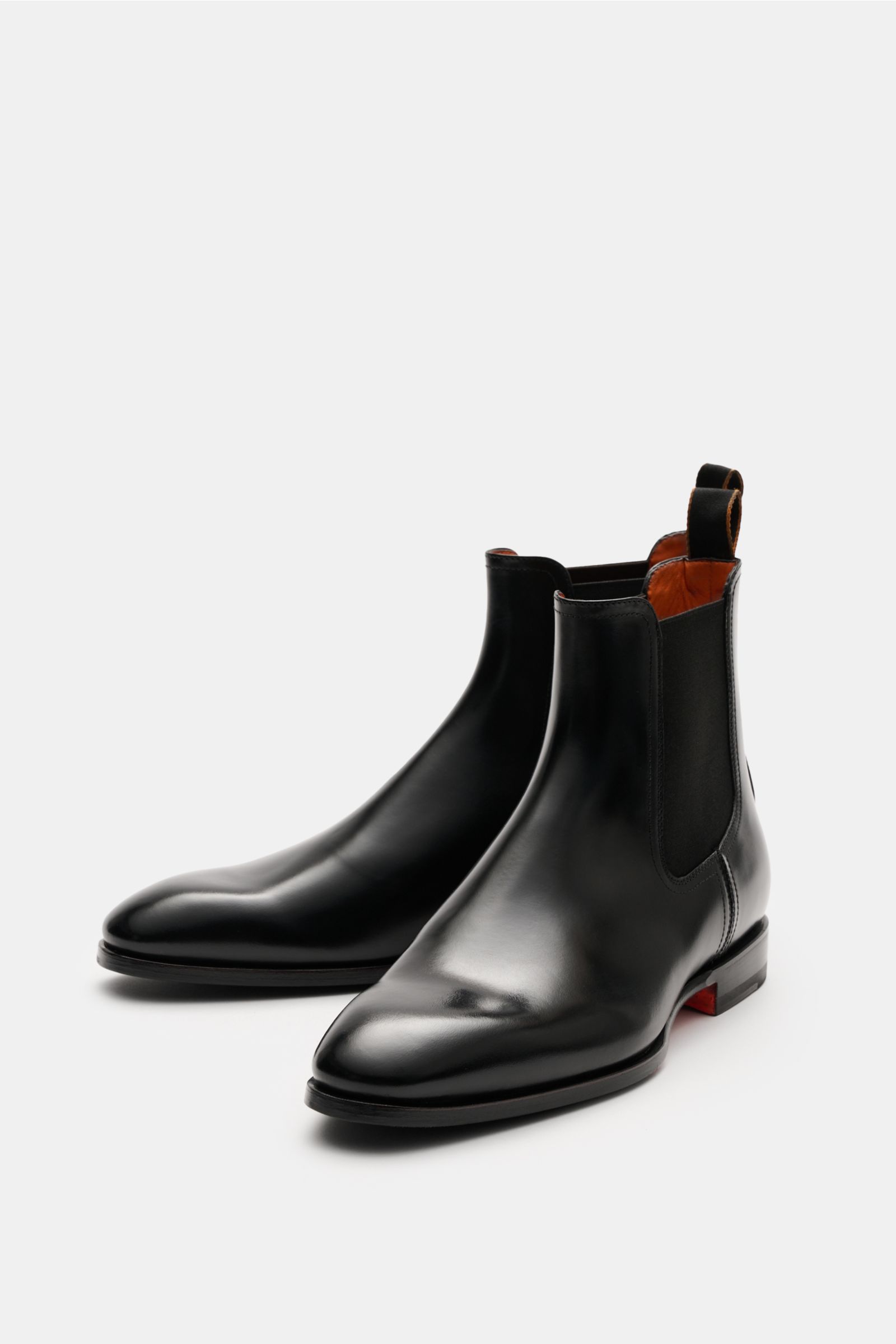 Santoni Chelsea Boot 'Adrian' schwarz shown from a front-side angle, crafted from smooth black leather with elastic side panels, a sleek tapered silhouette, leather lining, pull tabs, and a leather and rubber sole. 

Ein Klassiker – zeitlos und elegant