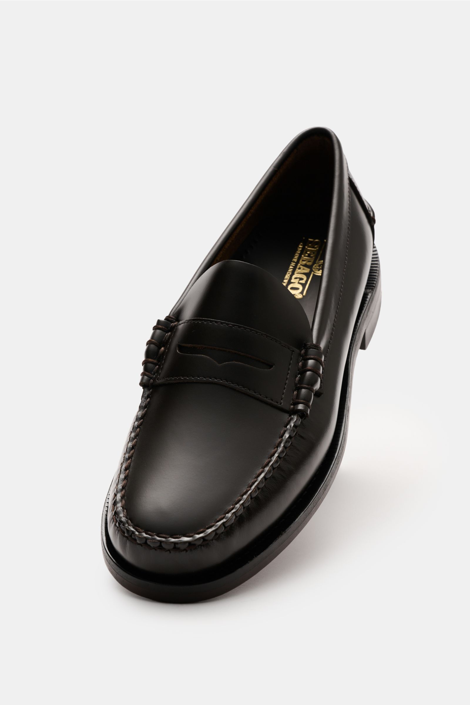 Sebago Penny Loafer 'Classic Dan' dunkelbraun aus fein genarbtem Leder, Blake-Verarbeitung, schmal zulaufend, Penny Strap, Ziernaht, ledernes Innenfutter, Ledersohle, Kautschukabsatz, frontal schräg fotografiert.