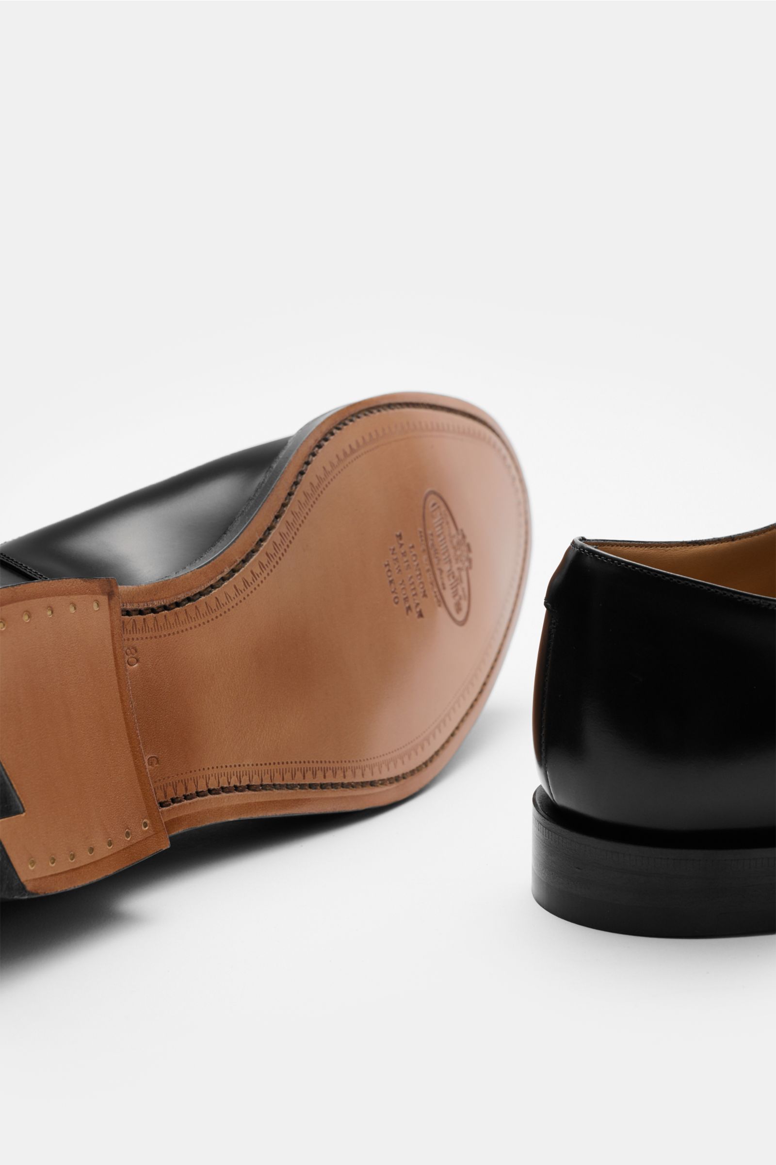 Church's Penny Loafer 'Maesteg' schwarz shown from a low rear and sole perspective, featuring polished smooth leather, Goodyear welted construction, a narrow silhouette, typical penny strap, decorative stitching, leather lining, leather sole, and rubber-r