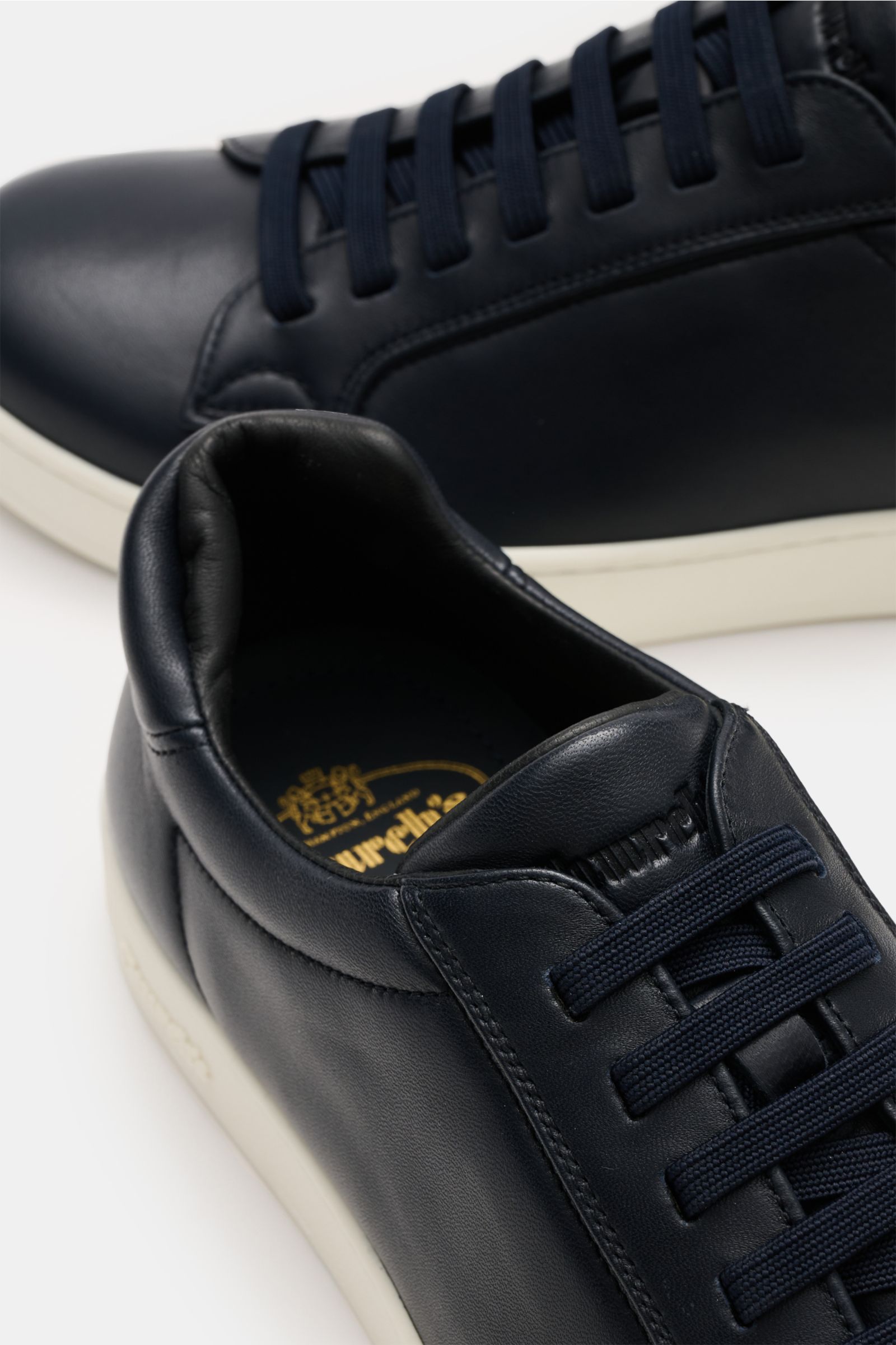 Church's Sneaker 'Ludlow' navy aus geschmeidigem Nappaleder, elastischer Sieben-Loch-Schnürung, gepolstertem Schaftrand, von oben fotografiert.