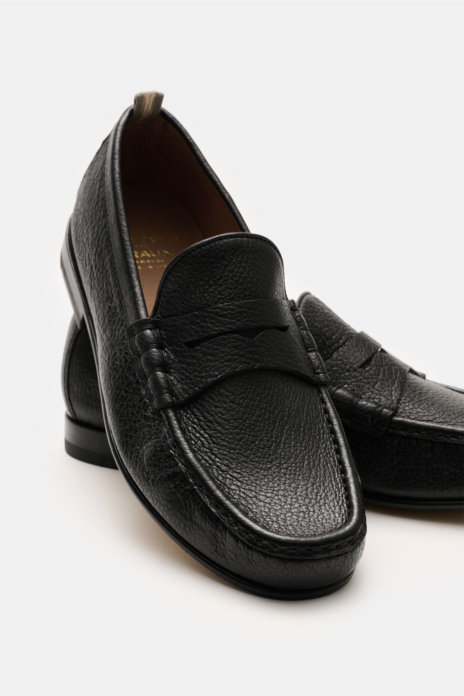 Officine Creative Penny Loafer 'Balfron' schwarz aus geschmeidigem Hirschleder, seitliche Ansicht mit typischem Penny Strap und Zierfalten.