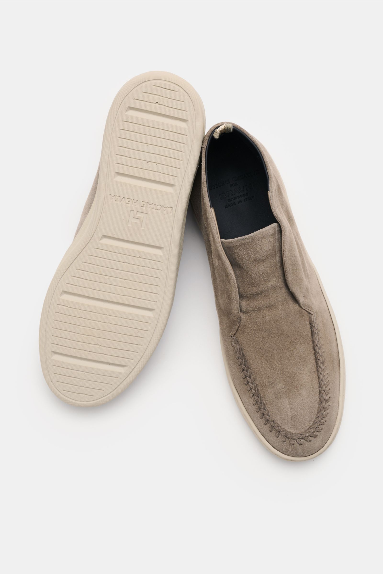 Officine Creative Loafer 'Herbie' taupe shown from above, one shoe top view with smooth velour leather, narrow silhouette, decorative seam, grosgrain loop, leather lining, and flexible rubber sole visible on the other shoe.