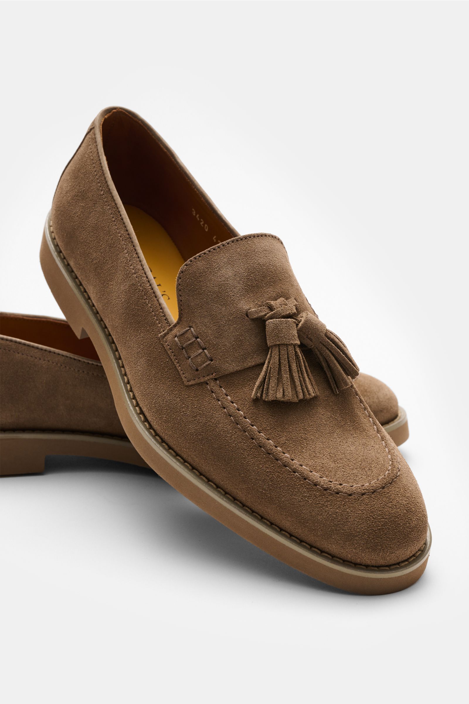 Front and side view of Doucal's Tassel Loafer 'Visone' braun in fine brown suede with typical tassels, stitched toe cap, leather lining, and flexible rubber sole, photographed from a slightly elevated angle. Wer einen klassischen Tassel Loafer sucht, l