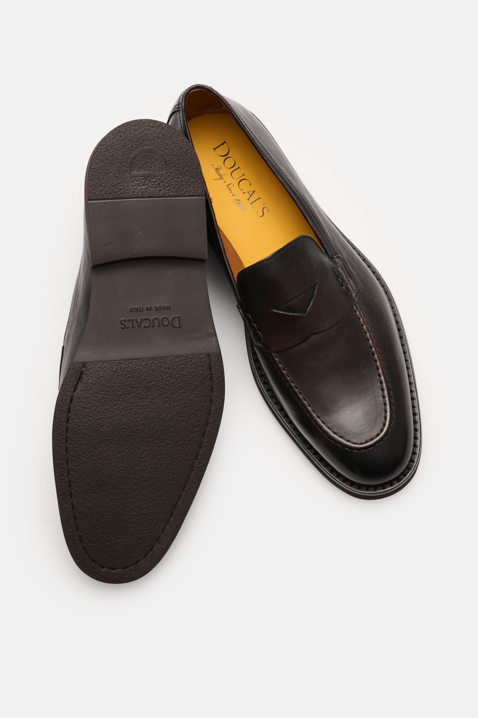 Doucal's Penny Loafer 'Triumph' dunkelbraun aus feinem Glattleder mit Penny Strap, Steppnaht und leichter Kautschuksohle, seitlich und von unten fotografiert.
