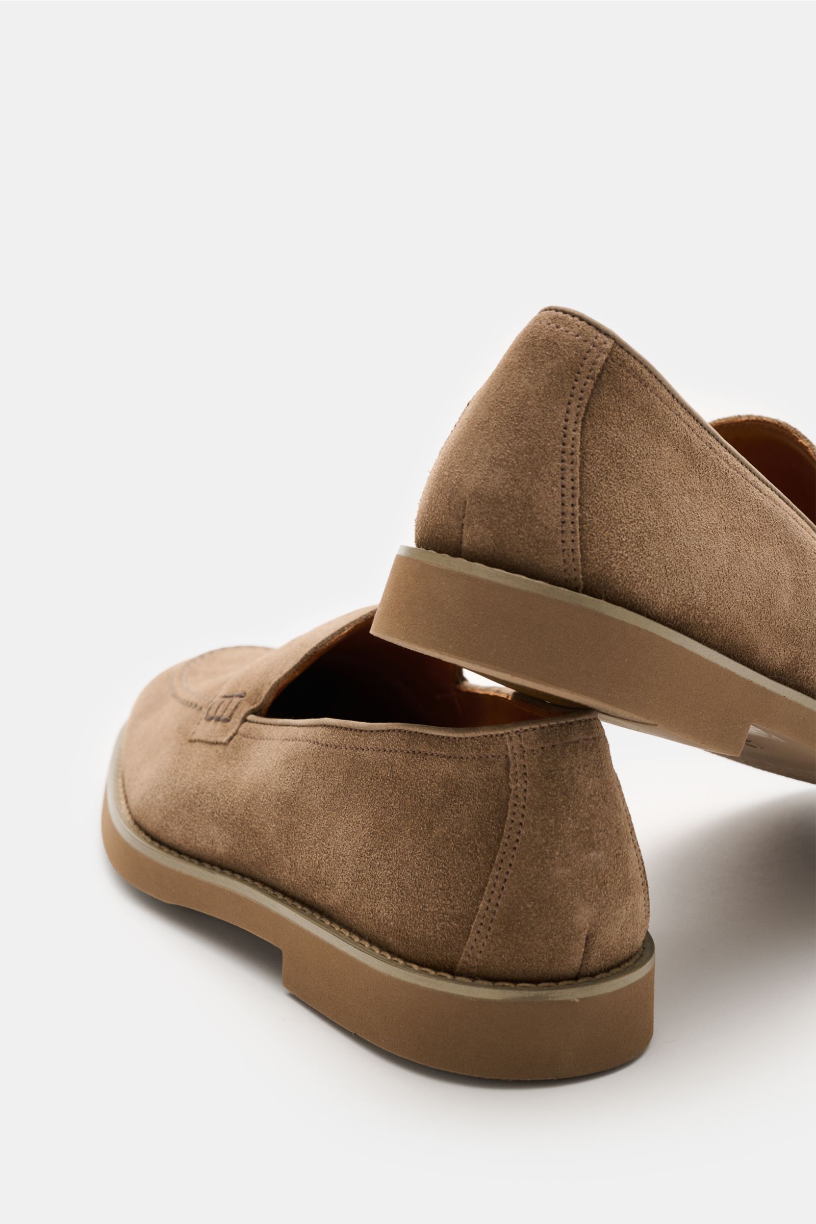 Doucal's Penny Loafer 'Visone' graubraun aus feinem Veloursleder, schmal zulaufend mit Penny Strap, Steppnaht, Lederfutter, Kautschuksohle, seitlich und leicht von hinten fotografiert.