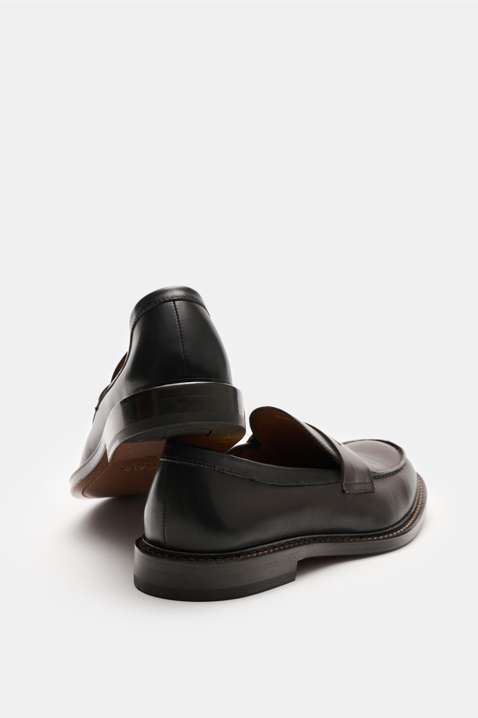 Doucal's Penny Loafer 'Nappato' dunkelbraun shown from rear-side and side view, made of fine smooth leather with light color gradient, pennystrap, stitched toe cap, leather lining, and stitched leather sole, slightly tapered silhouette.