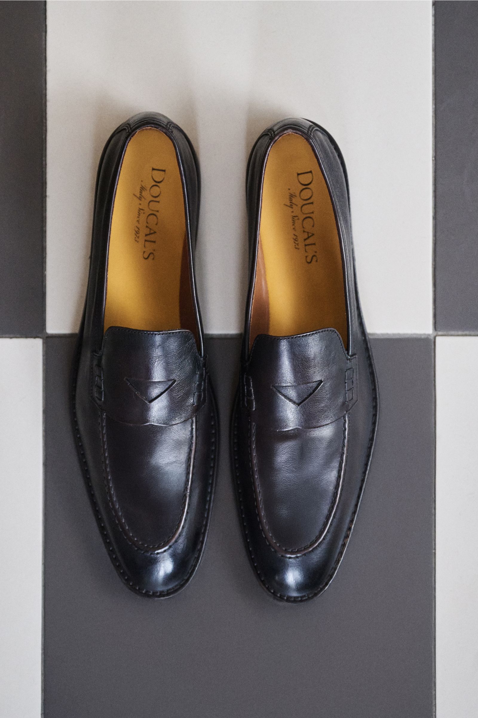 Doucal's Penny Loafer 'Nappato' dunkelbraun aus feinem Glattleder mit leichtem Farbverlauf, Pennystrap und durchgenähter Ledersohle, von oben fotografiert.