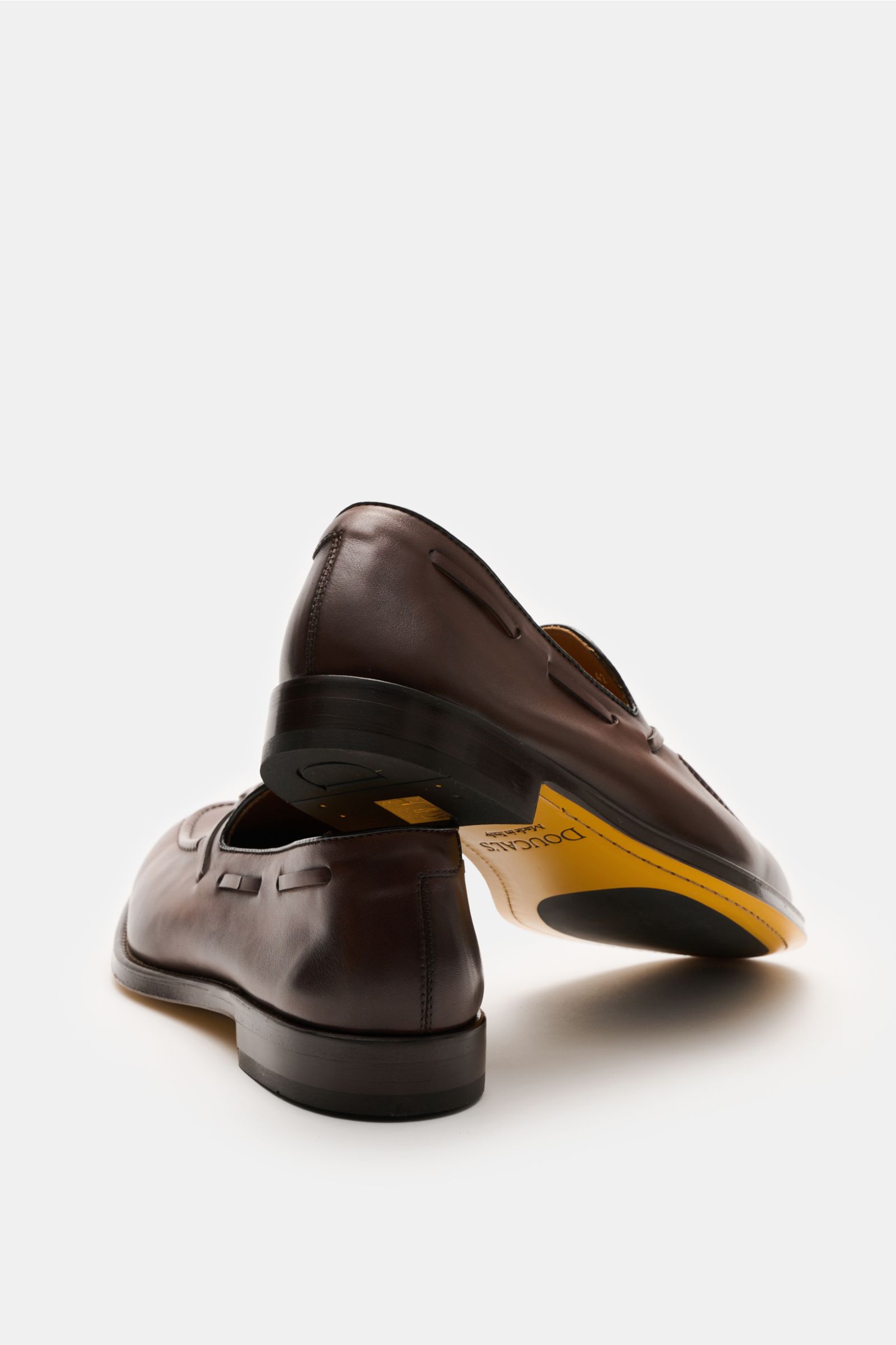 Doucal's Tassel Loafer 'Nappato' braun aus feinem Glattleder, schmal zulaufend, mit Steppnaht, Lederband, Lederfutter, Ledersohle mit Kautschuk, seitlich und von unten fotografiert.