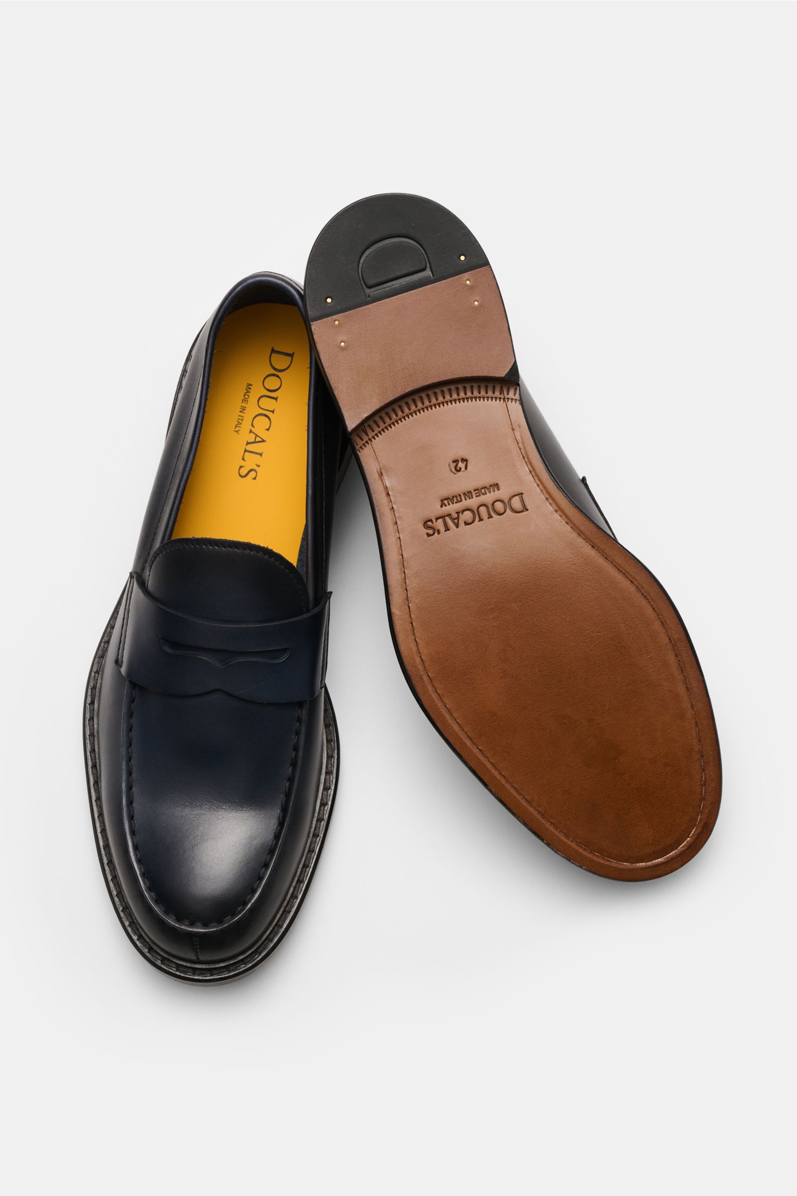 Doucal's Penny Loafer 'Nappato' dark navy shown from top and sole view, classic loafer in fine smooth leather with slight color gradient, narrow tapering, stitched toe cap, typical penny strap, leather lining, hand-stitched construction, and leather sole,