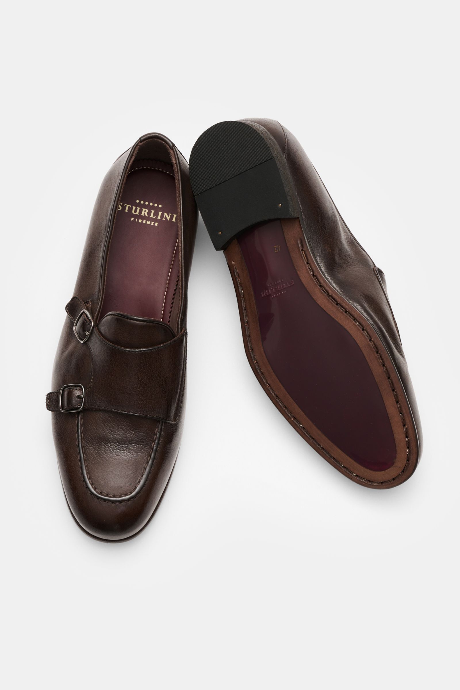 Sturlini Doppelmonk 'Bufalo' dunkelbraun, aus geschmeidigem Leder mit abgerundeter Vorderkappe, silberfarbenen Dornschließen, ledernem Innenfutter und Gummisohle, von oben fotografiert.