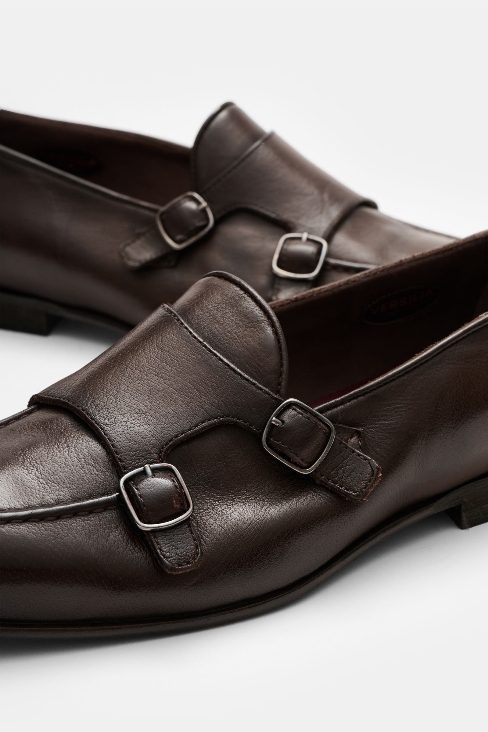 Sturlini Doppelmonk 'Bufalo' dunkelbraun, seitlich nah aufgenommen, aus geschmeidigem Leder mit Doppel-Dornschließen, abgerundeter Vorderkappe, Querkappe, ledernem Innenfutter, Laufsohle aus Leder und Gummi, Absatz mit Kautschukverstärkung.