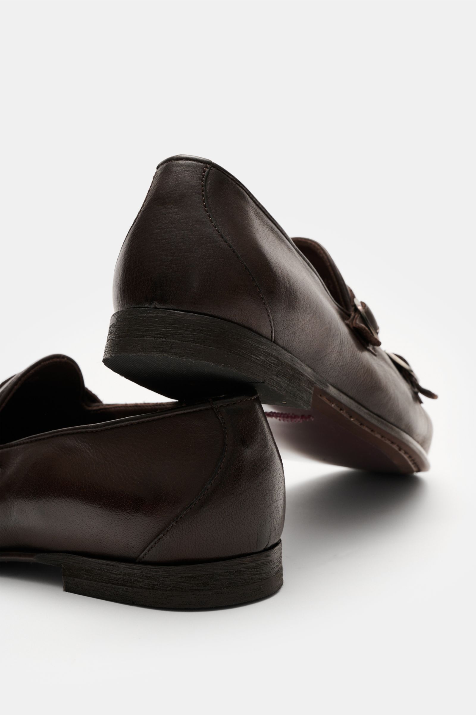 Sturlini Doppelmonk 'Bufalo' dunkelbraun aus geschmeidigem Leder mit abgerundeter Vorderkappe, Querkappe, silbernen Dornschließen, Lederfutter, Leder-Gummi-Laufsohle und Kautschuk-Absatz, fotografiert aus seitlich-hinten unten.