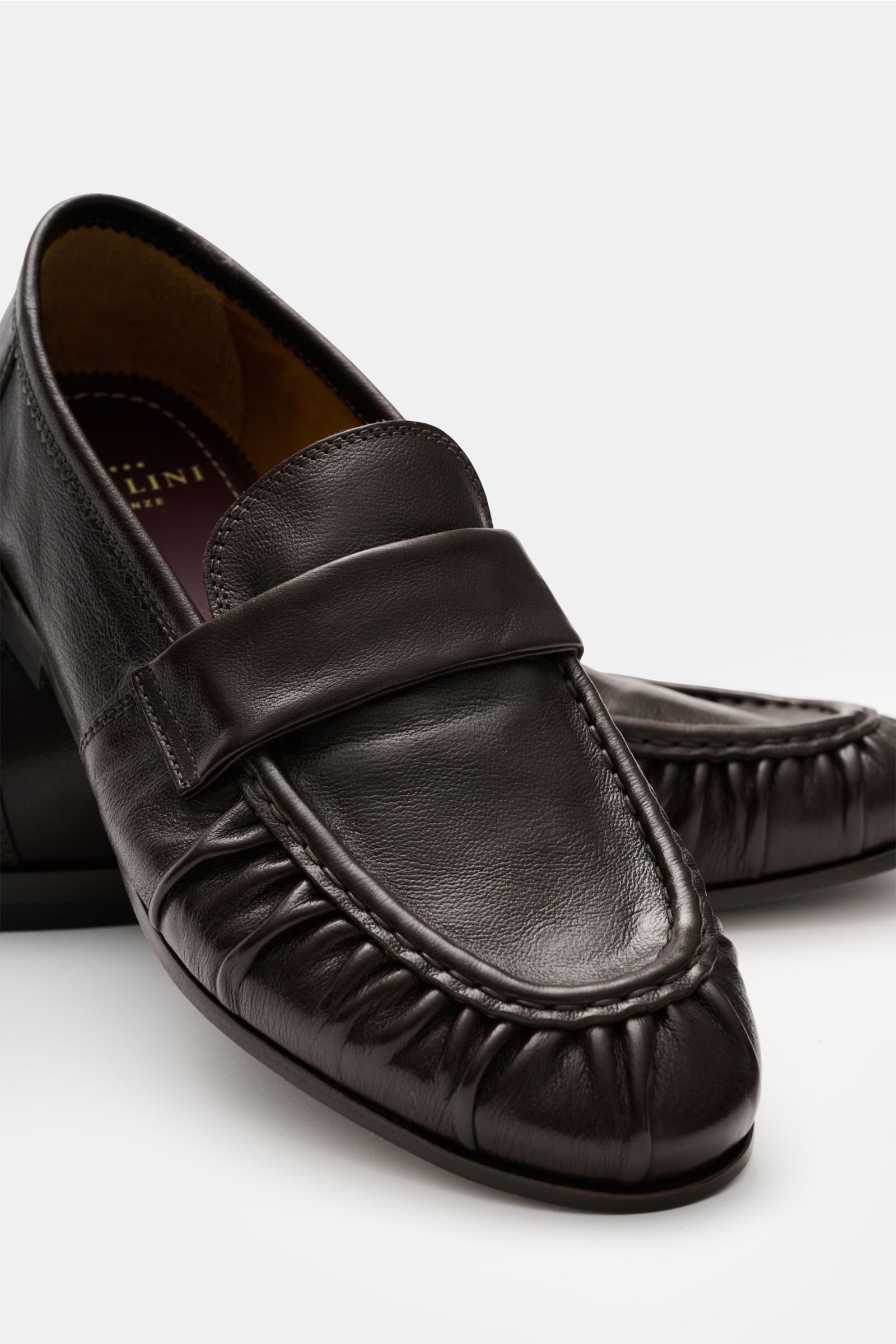 Sturlini Penny Loafer 'Salice' dunkelbraun, schmal zulaufend, aus Glattleder mit Penny-Strap, Naht vorn, Leder-Gummi-Laufsohle, aus schräger Frontperspektive.