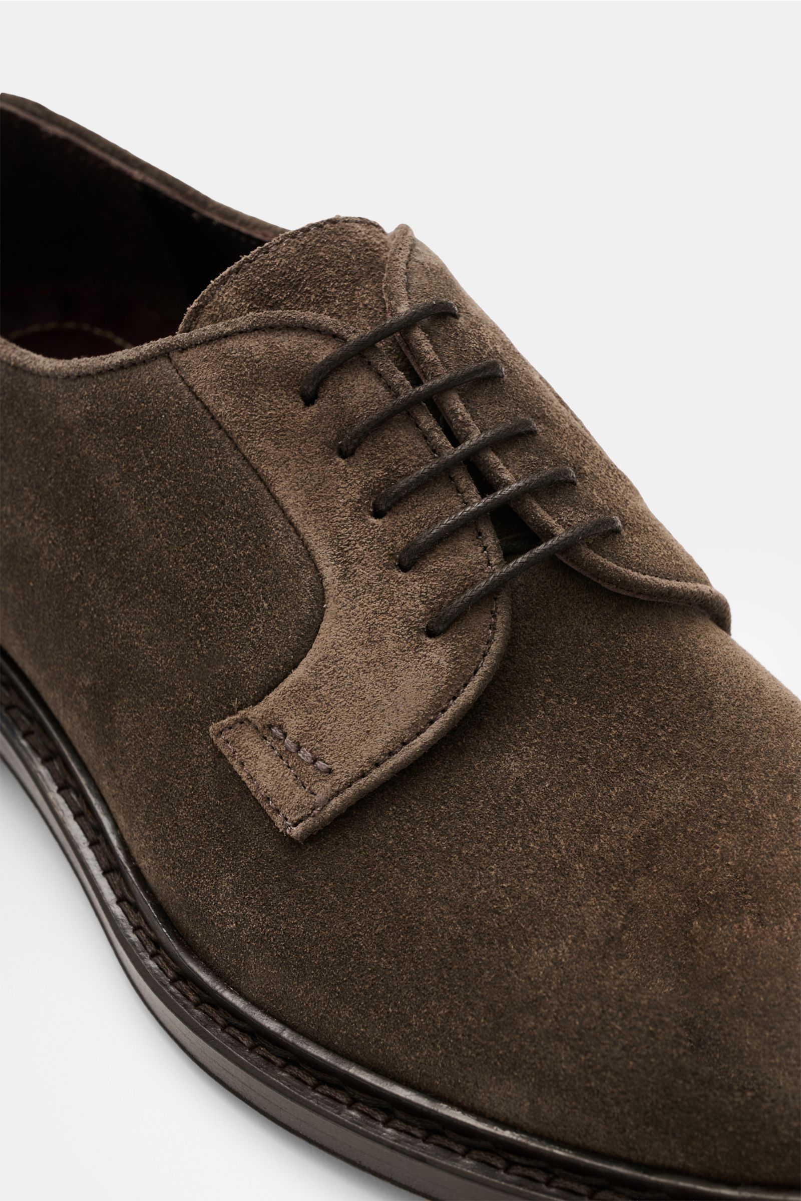 Sturlini Derby 'Softy' graubraun aus geschmeidigem Veloursleder, schmal zulaufend, offene Fünf-Loch-Schnürung, Leder- und Gummisohle, Nahaufnahme schräg von vorn.