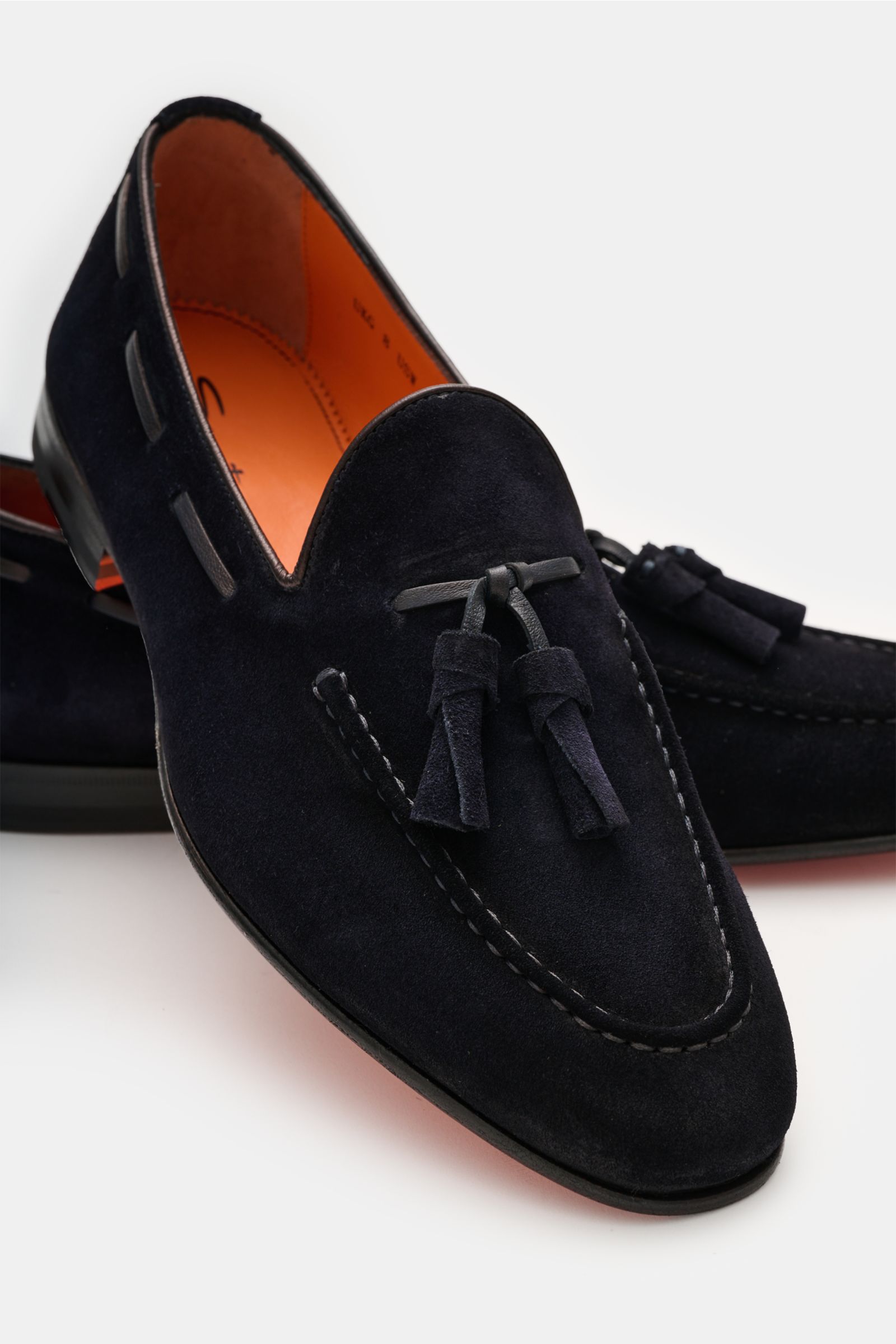 Santoni Tassel Loafer 'Carlos' navy shown from a front-side angle, crafted from soft velour leather with a narrow silhouette, Goodyear-welted, featuring a decorative stitched toe cap, typical tassels, leather lining, ultra-flexible leather sole, and rubbe