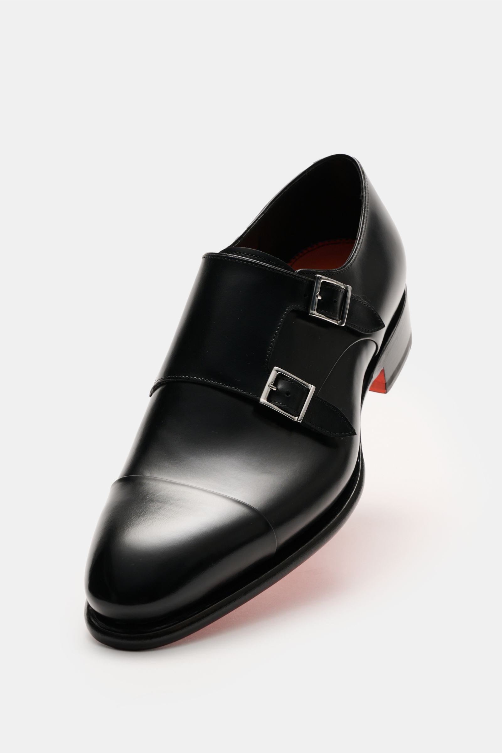 Front-side view of Santoni Doppelmonk schwarz, an elegant black shoe with noble calf leather, rounded toe cap, silver buckles, leather lining, and rubber-reinforced heel.