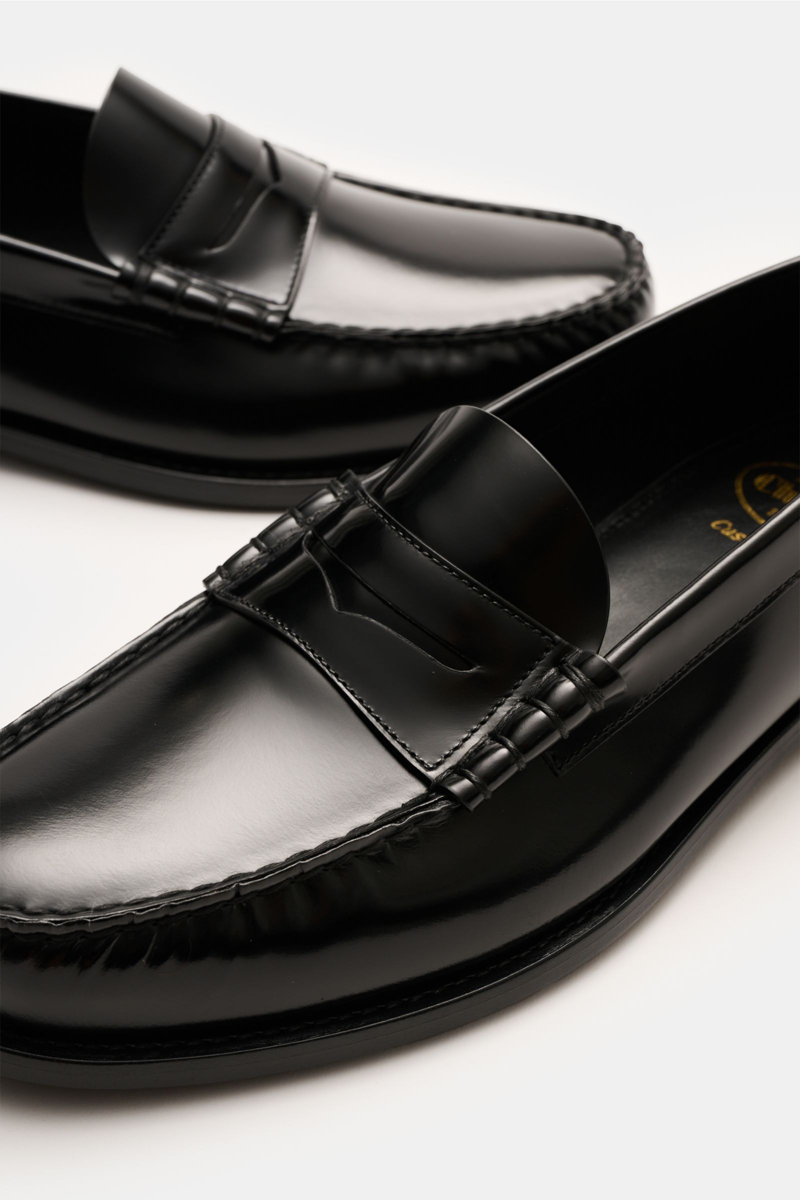 Close-up top-front angle of Church's Penny loafers 'Rowley' black in polished smooth leather with signature penny strap and decorative stitching.

Description:
The penny loafers 'Rowley' by CHURCH'S feature decorative stitching and polished smooth leat