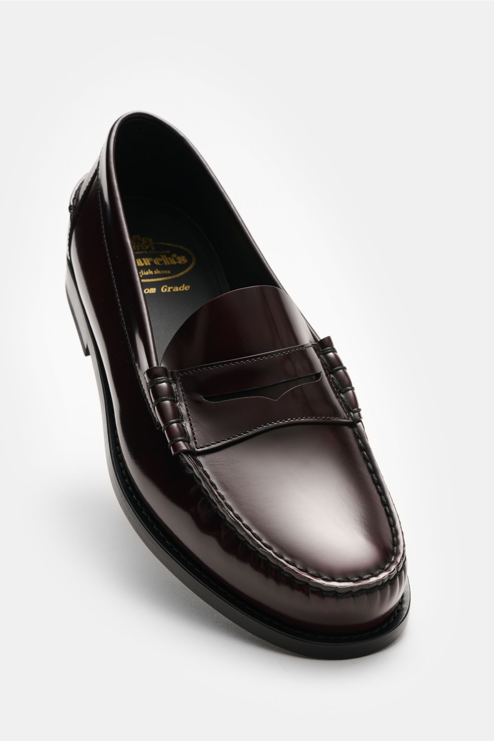 Church's Penny Loafer 'Rowley' bordeaux shown from a high front angle, polished smooth leather with penny strap, decorative stitching, leather lining, leather sole, rubber-reinforced heel, Goodyear welted, slightly tapered silhouette for stylish British l