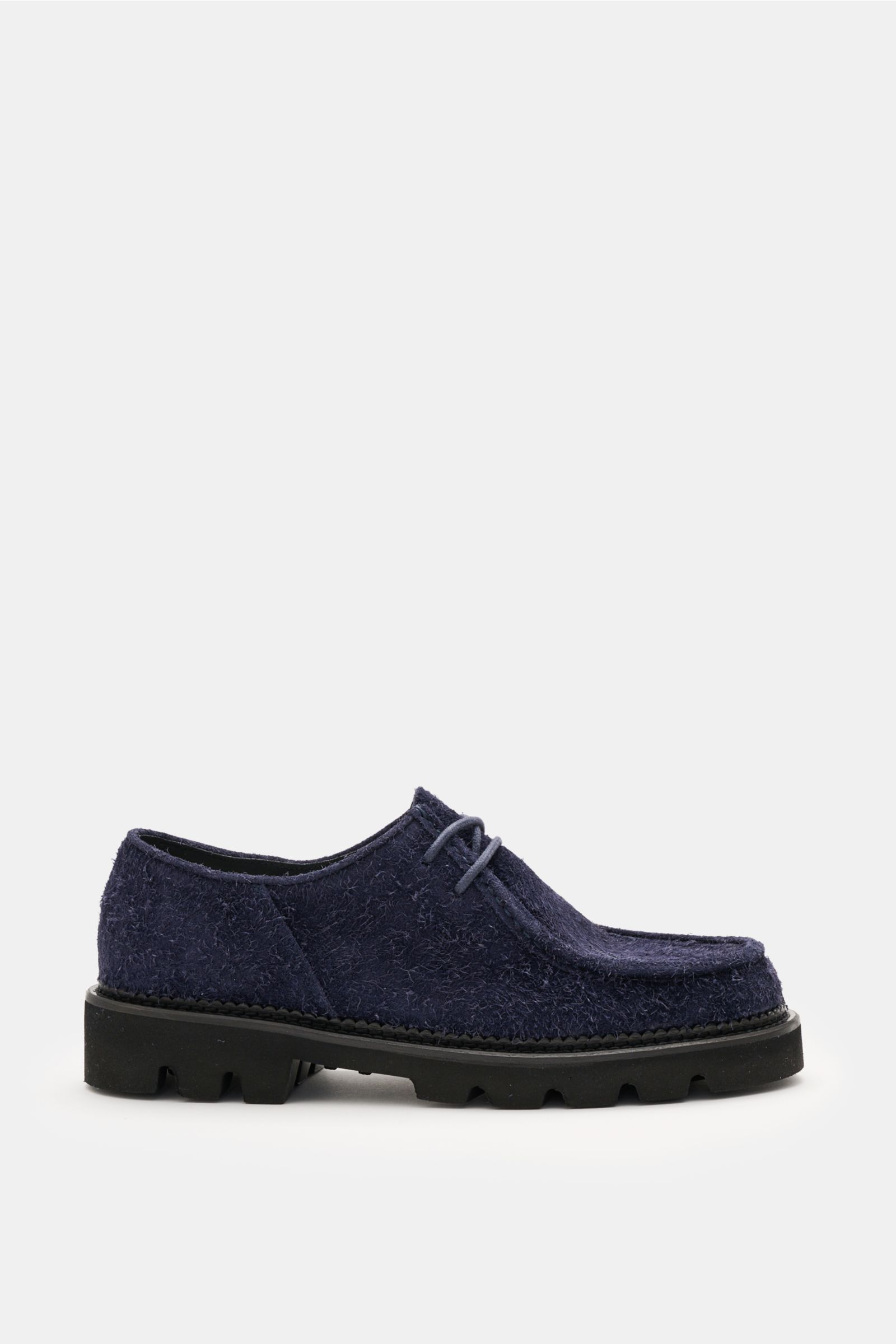 Collegium Derby 'Pillar Moc-Toe' navy shoe shown from the side, featuring smooth navy velour leather, narrow silhouette, open two-eyelet lacing, decorative cap seam, leather lining, and rubber lug sole. Eyecatcher for transitional seasons: the 'Pillar Moc