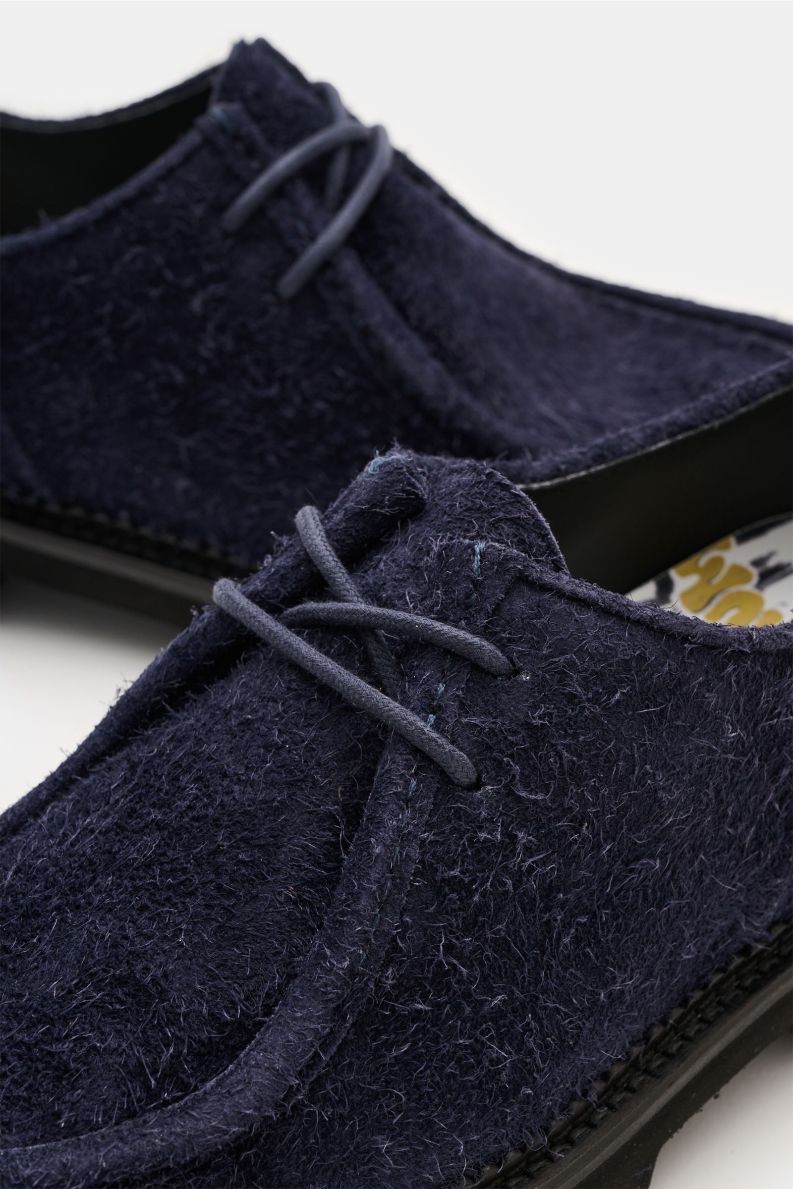 Close-up front-side view of Collegium Derby 'Pillar Moc-Toe' navy shoes in soft navy velour leather, featuring slim silhouette, open two-eyelet lacing, decorative cap stitching, leather lining, and rubber profile sole. Eyecatcher for transitional seasons: