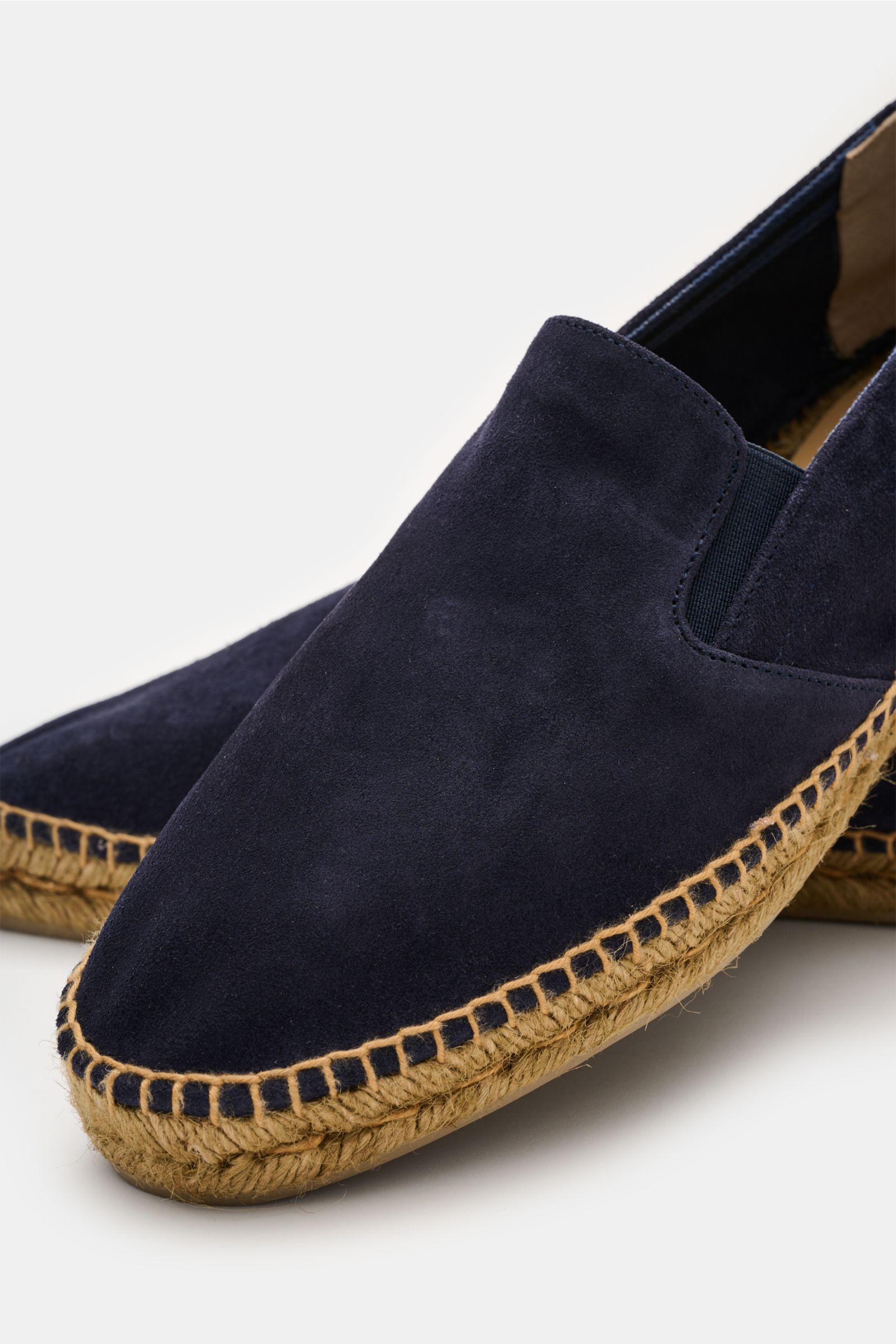 Close-up front-side view of Castañer Espadrilles 'Joel' navy made of smooth velour leather with jute-trimmed vulcanized rubber sole and side elastic inserts. Legerer Klassiker: Mit diesen Espadrilles aus Leinen von CASTAÑER mit vulkanisierter Gummisohle m