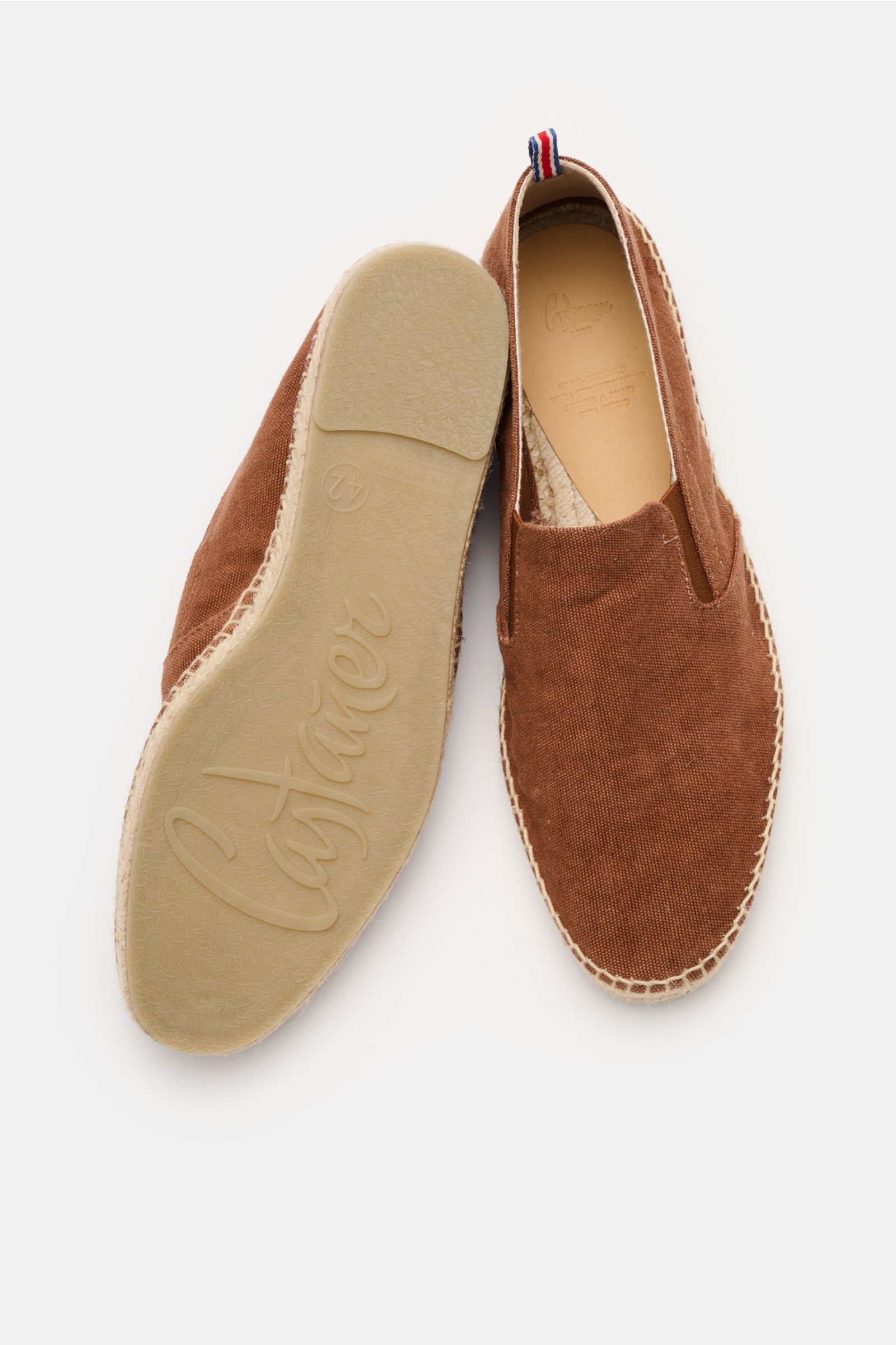 Castañer Espadrilles 'Joel' rostbraun shown from above, featuring canvas cotton, elastic inserts, jute trim, decorative stitching, and rubber sole.

Die Espadrilles 'Joel' von CASTAÑER aus Canvas verbinden gekonnt die markentypische vulkanisierte Gummi