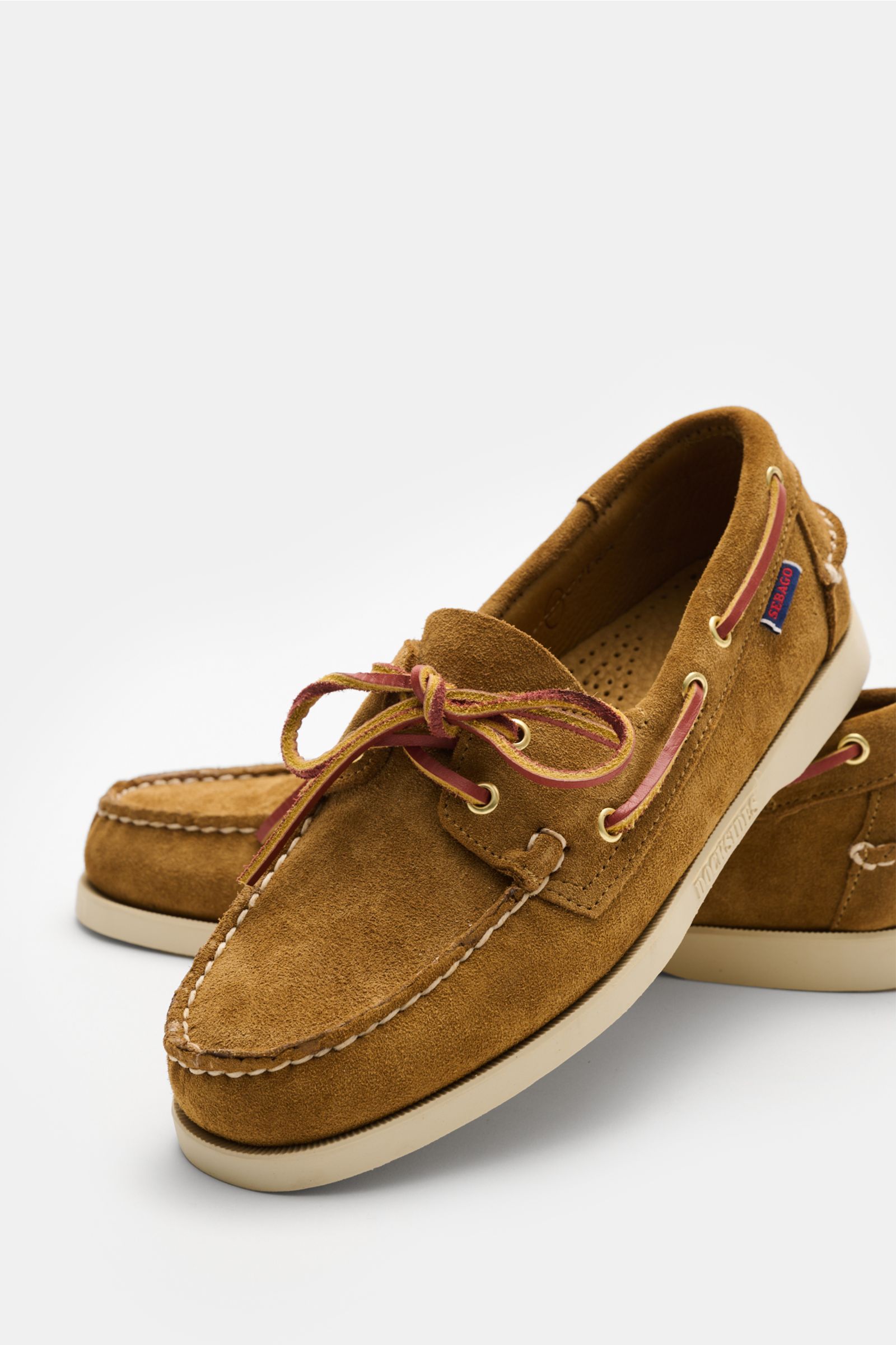 Front-side angled view of Sebago Loafer 'Portland Artisan' camel in smooth suede with a slightly tapered silhouette, leather lacing, decorative toe stitching, leather lining, and flexible rubber sole, showcasing a timeless and comfortable classic boat sho