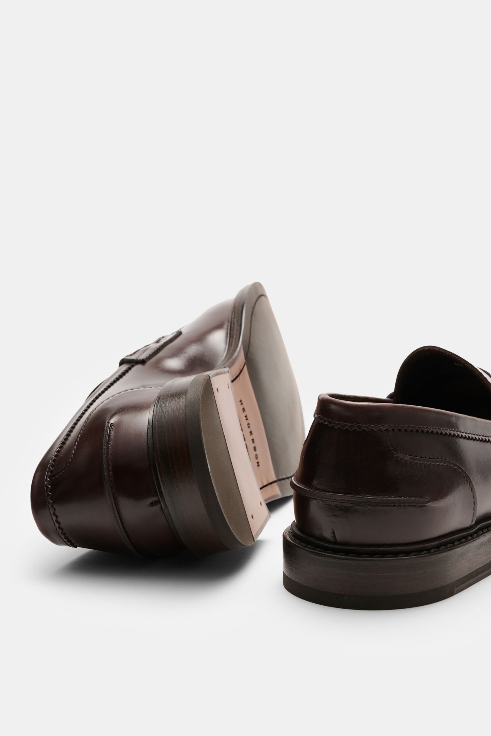 Henderson Penny Loafer 'Calf Lux Sparrow' dunkelbraun aus poliertem Glattleder, schmal zulaufend, mit Penny-Strap, Ziernaht, Goodyear-welted, Lederlaufsohle und Kautschukabsatz, rückwärtige Perspektive.