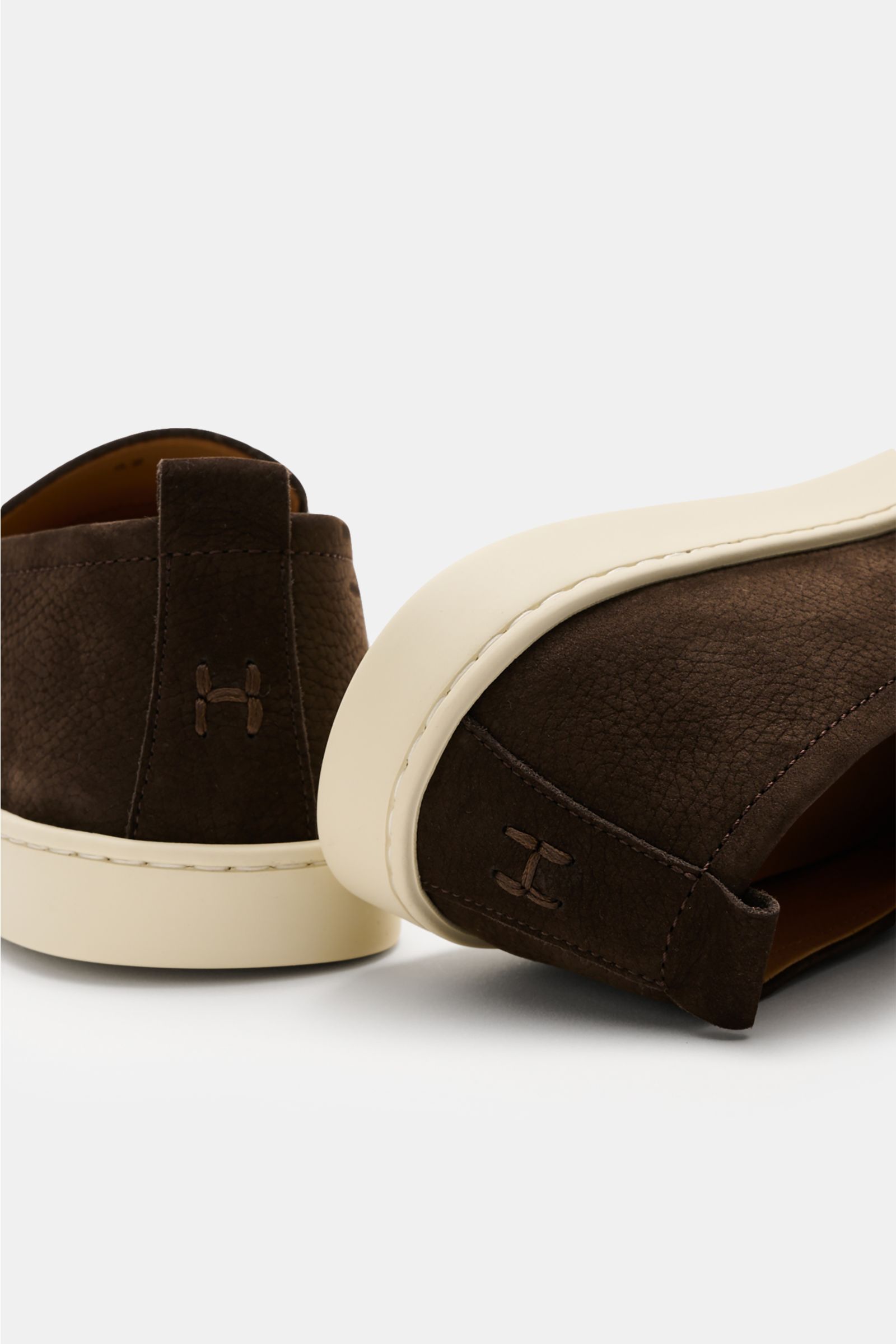 Henderson Penny Loafer 'Mentone' dunkelbraun aus Nubuk-Kalbsleder, flexible Gummisohle, Logo-Stitching an der Ferse, Rückansicht schräg.