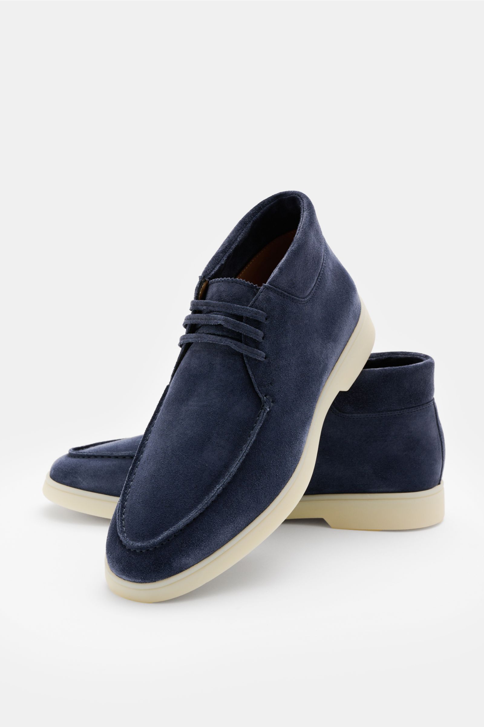 Aurélien Desert Boot blau aus geschmeidigem Veloursleder, schmal zulaufend, mit offener Drei-Loch-Schnürung, Naht, gepolstertem Schaftrand und flexibler Gummisohle, seitlich-vorne fotografiert.