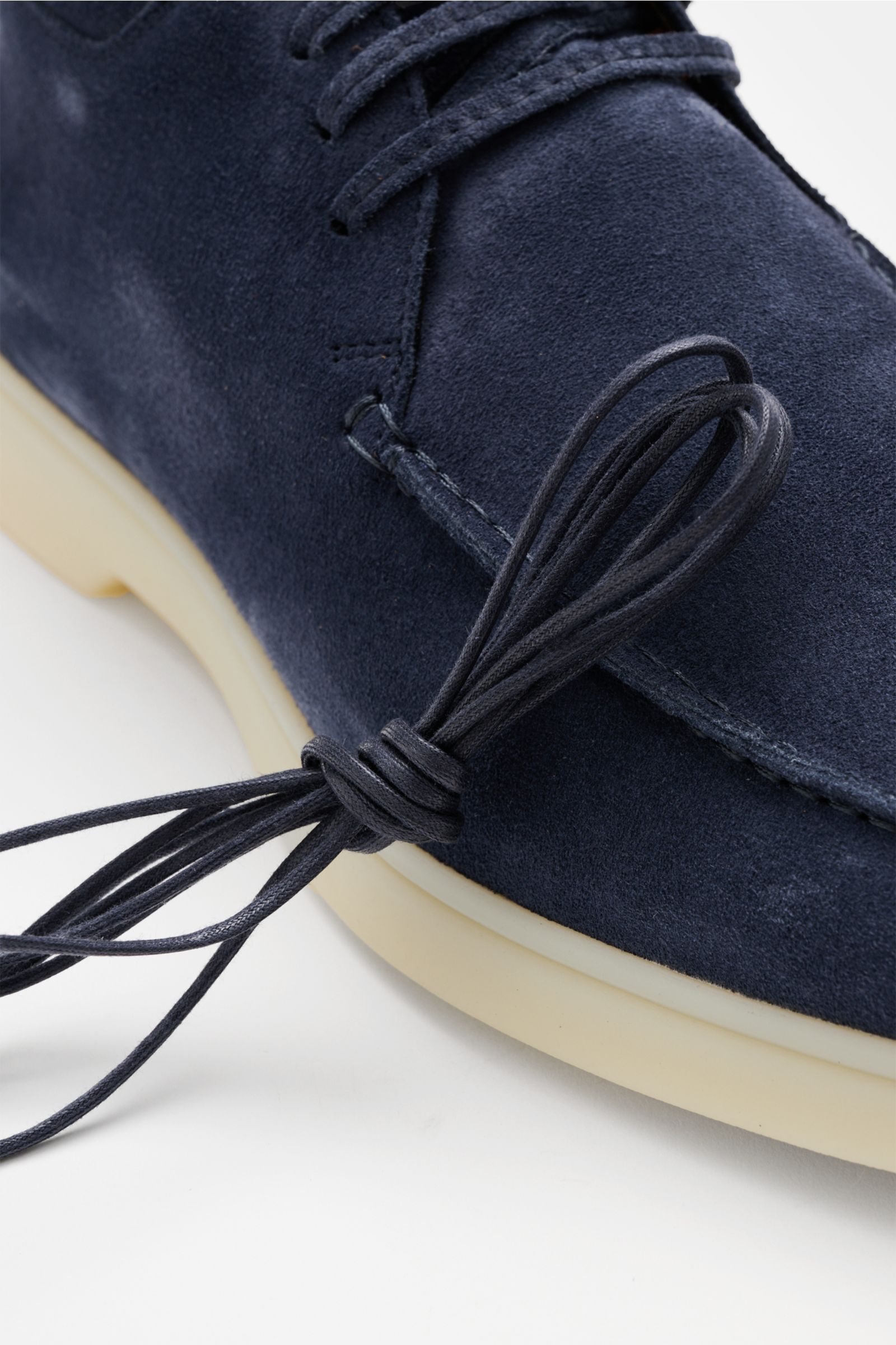 Nahaufnahme des Aurélien Desert Boot blau aus geschmeidigem Veloursleder, schmal zulaufender Silhouette, offener Drei-Loch-Schnürung, markanter Naht und flexibler Gummisohle.