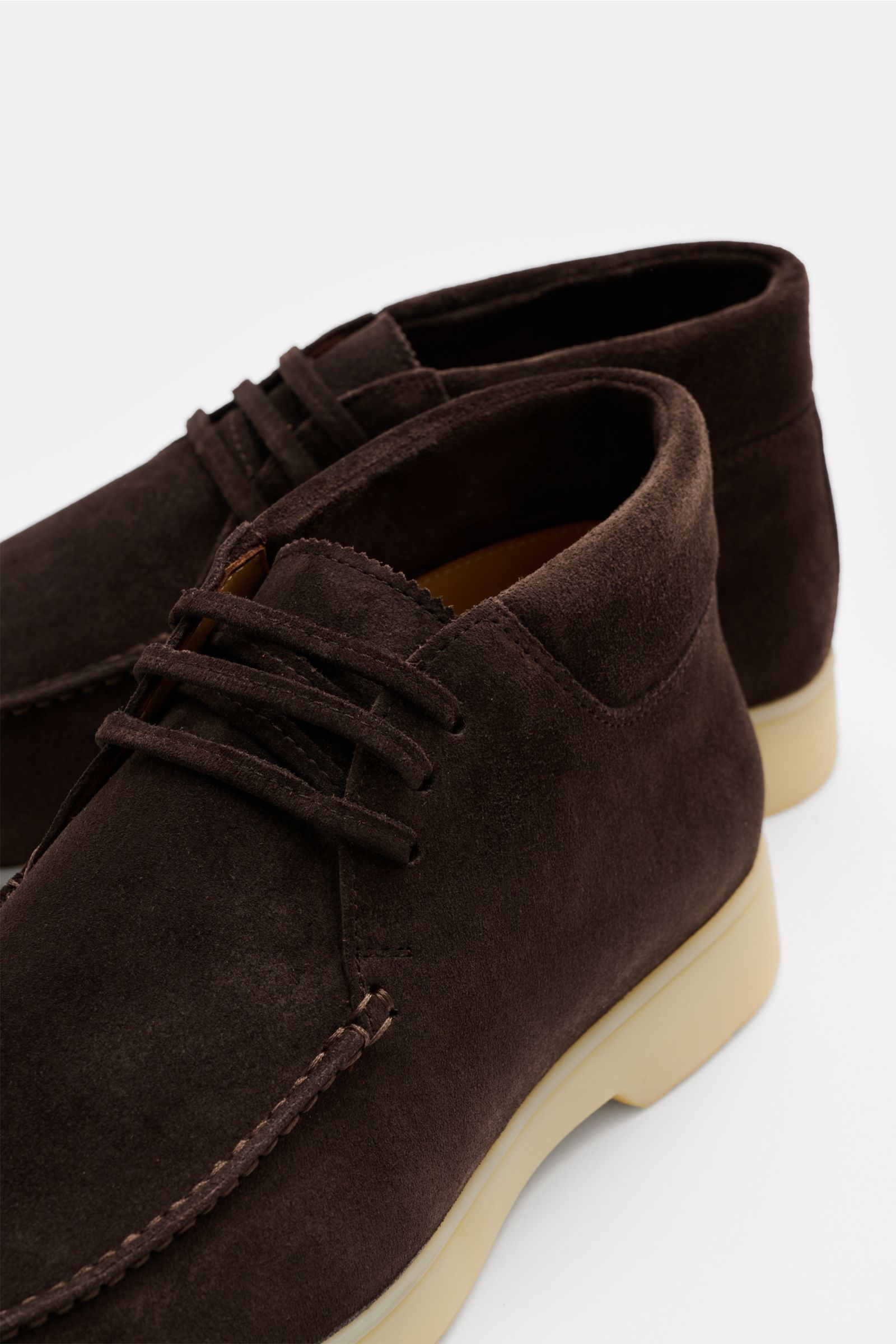 Aurélien Desert Boot dunkelbraun shown from a close-up front side angle, made of soft velour leather with a slightly tapered silhouette, open three-eyelet lacing, prominent front cap seam, padded collar, leather lining, flexible rubber sole, and extra pai