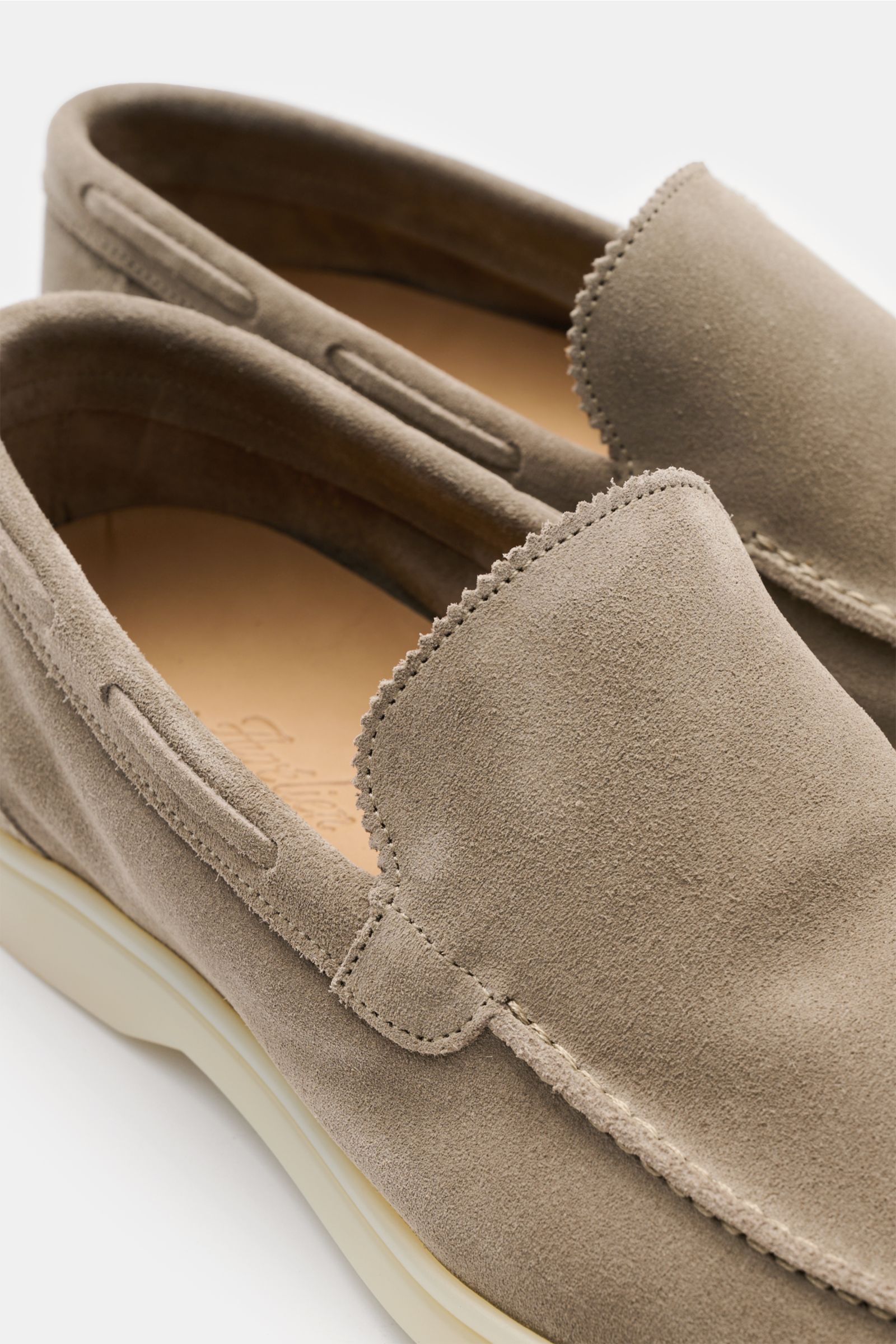 Close-up top-side view of Aurélien Loafer 'Yacht 2.0' taupe made of smooth suede leather, featuring a narrow silhouette, distinctive seam on the toe cap, hand-stitched edges with a subtle zigzag pattern on the tongue, leather lining, and a flexible rubber