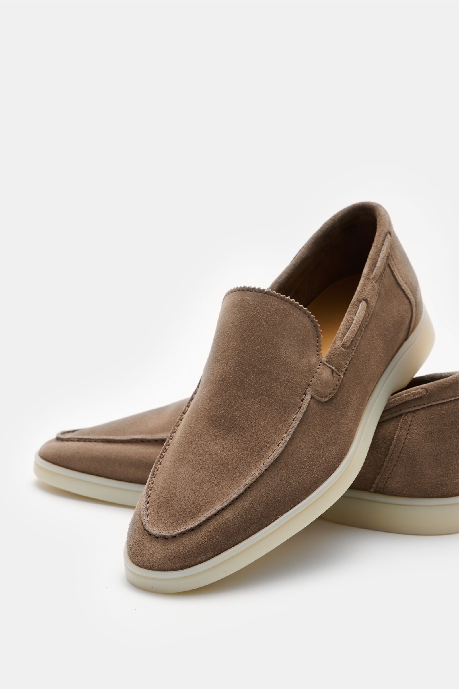 Aurélien Loafer 'Yacht 2.0' graubraun, aus geschmeidigem Veloursleder, schmal zulaufend, mit Zickzackrand, handgenähten Nähten, ledernem Innenfutter und flexibler Gummisohle, frontal aus schräger Perspektive fotografiert.