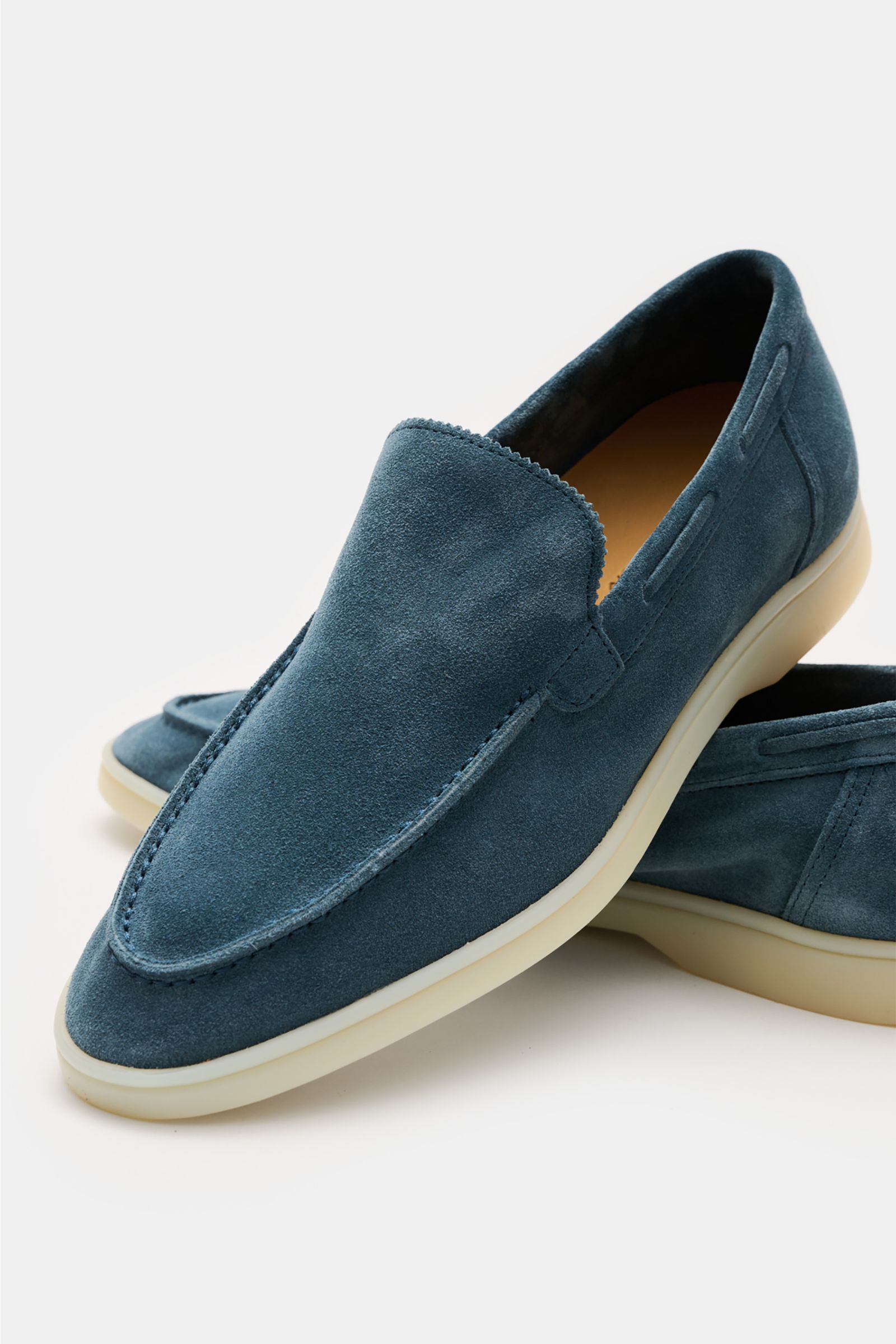 Front-side close-up of Aurélien Loafer 'Yacht 2.0' rauchblau in soft blue suede with hand-stitched seams, flexible white sole, slim silhouette, and leather lining, showcasing the zigzag edge on the tongue and detailed craftsmanship.
