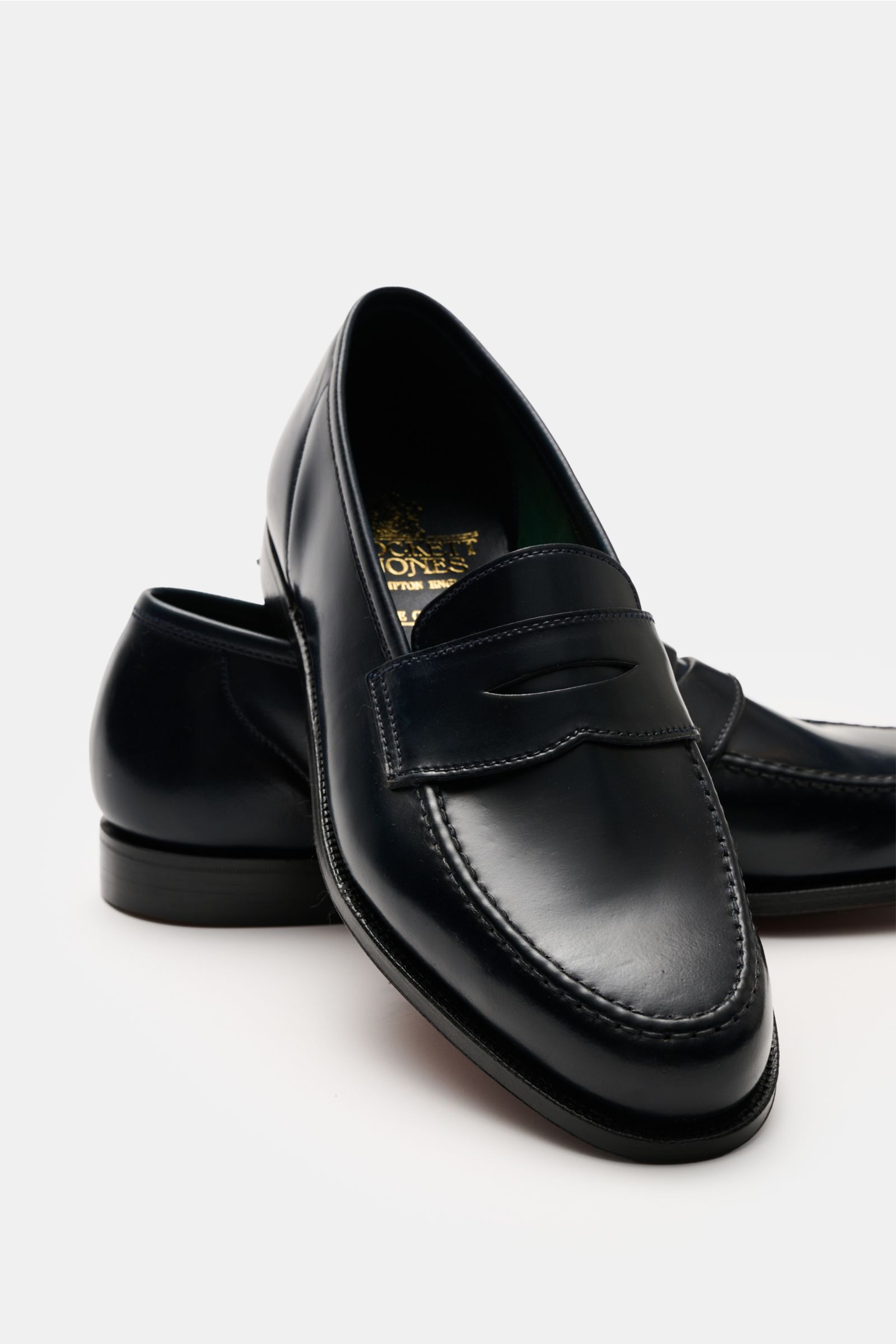 Close-up side-front view of Crockett & Jones Penny Loafer 'Harvard' navy in polished smooth leather, with penny strap and leather sole.

Description: Elegantes Modell aus Glattleder von CROCKETT & JONES: Mit seinem glänzenden Finish und edler Leder