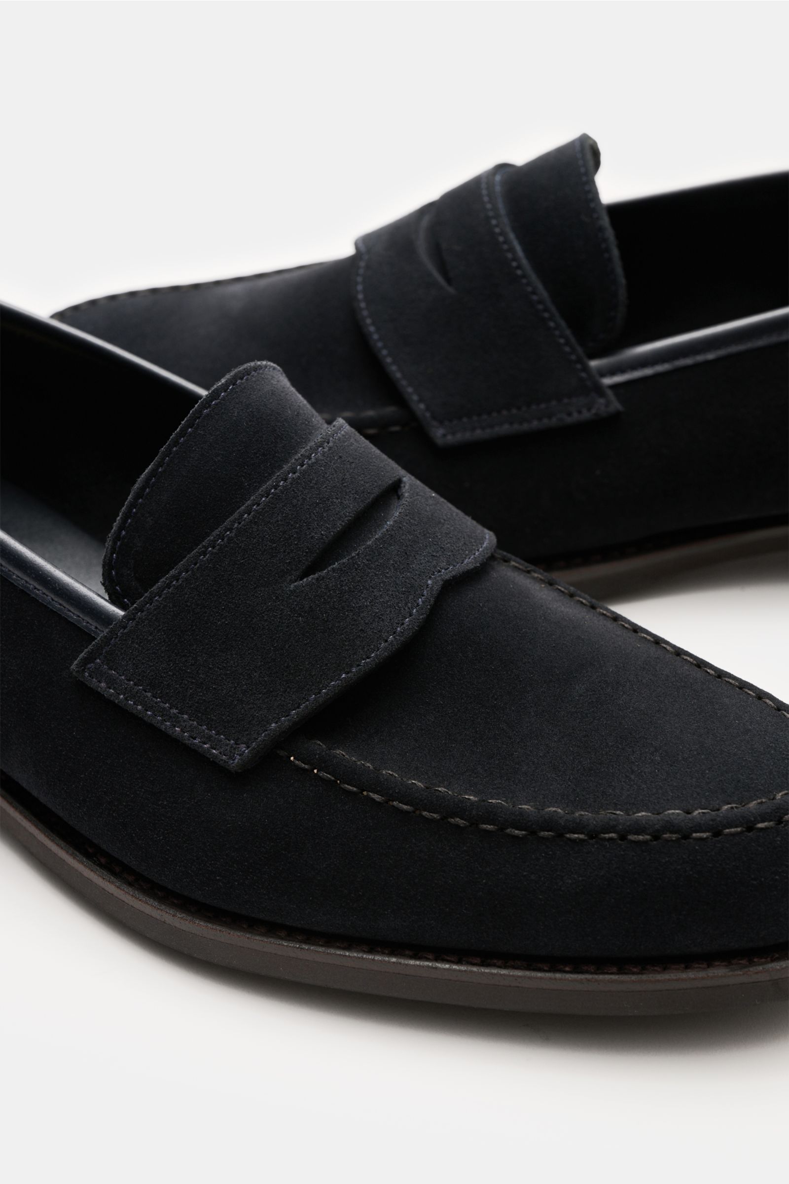 Nahaufnahme von Crockett & Jones Penny Loafer 'Harvard' navy aus geschmeidigem Veloursleder mit wasserabweisendem Finish, Penny Strap, Steppnaht und rutschsicherer Kautschuksohle, schmal zulaufend, seitliche Perspektive.