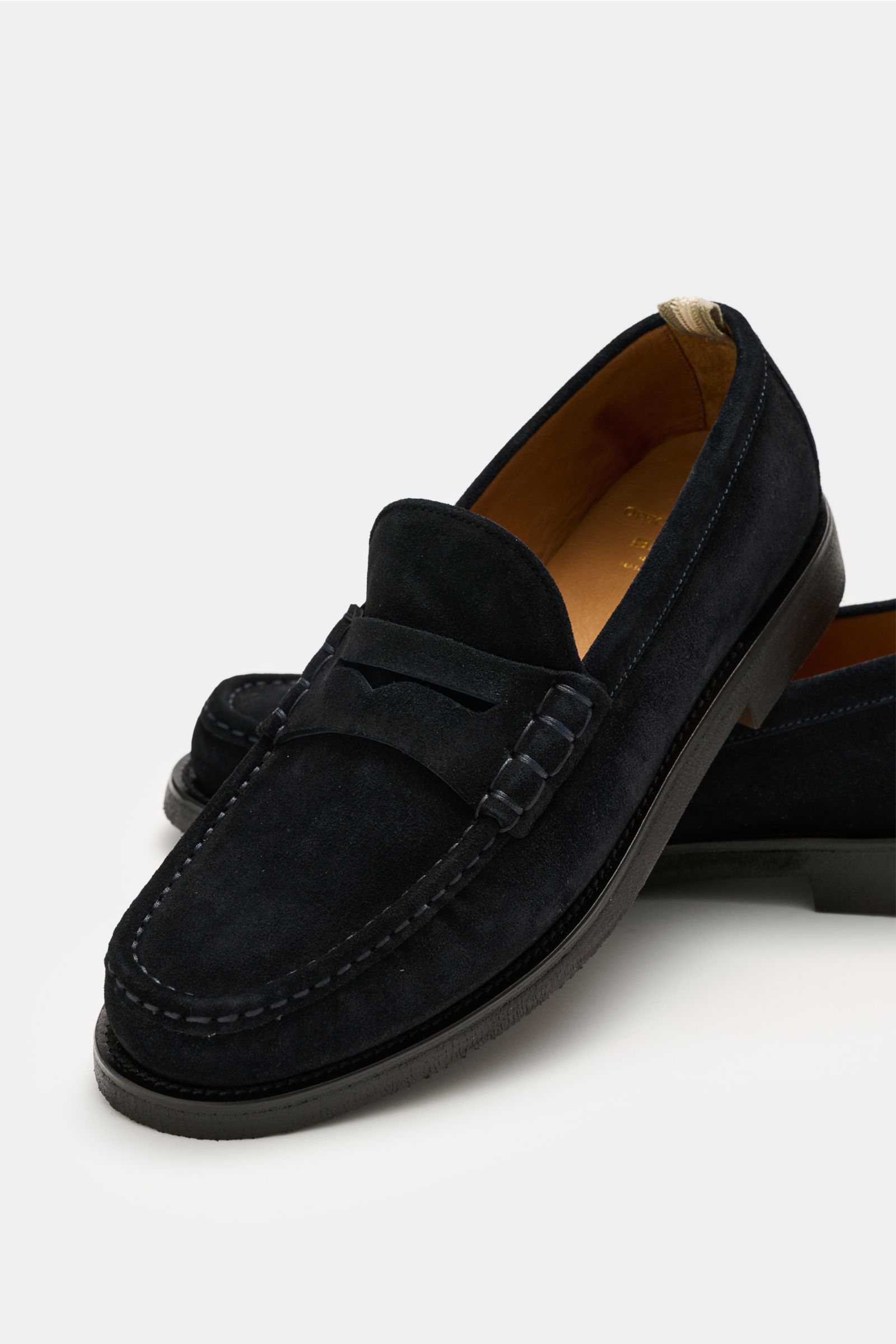Officine Creative Penny Loafer 'Balfron Flexi 001' dark navy in soft suede with penny strap, visible stitching, and natural rubber sole, shown from a close-up side angle. Entspannte Eleganz: Der Penny Loafer 'Balfron Flexi 001' von OFFICINE CREATIVE verei
