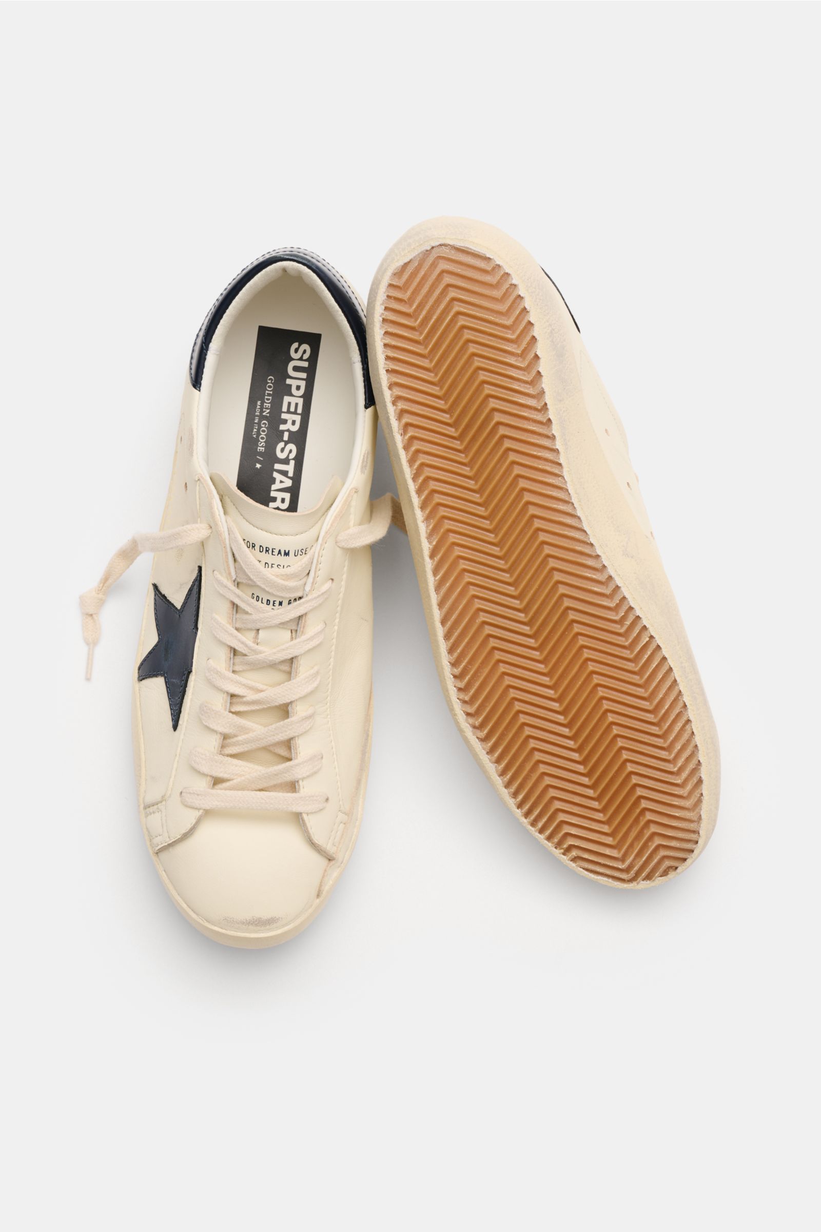 Golden Goose Sneaker 'Super-Star Classic' offwhite/hellgrau shown from top view with one shoe upright and one sole visible. Für alle, die Patina feiern statt Perfektion: Der 'Super-Star Classic' bringt mit Vintage-Finish, dem ikonischen Stern und handgema