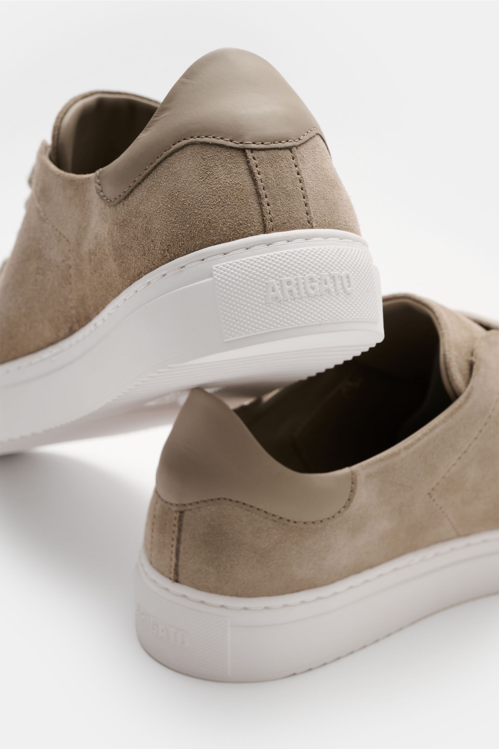 Rear and side view of the Axel Arigato Sneaker 'Clean 90' taupe, featuring edles Veloursleder, runde Vorderkappe, flexible Gummisohle, and goldfarbene Label-Prägung.