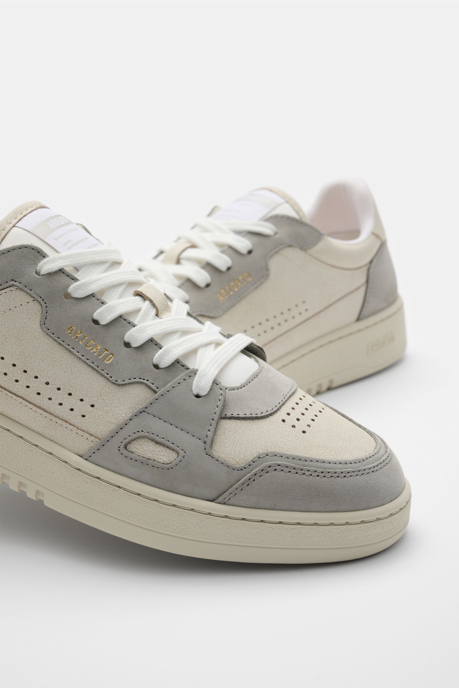 Axel Arigato Sneaker 'Dice Lo' beige/hellgrau, Nahaufnahme schräg von vorne, hochwertiges Glattleder, Nubuk-Overlays, perforierte runde Vorderkappe, sechs-Loch-Schnürung, Lasche mit Weblabel, goldfarbene Prägung, gepolsterter Schaftrand, recyceltes Mesh-F